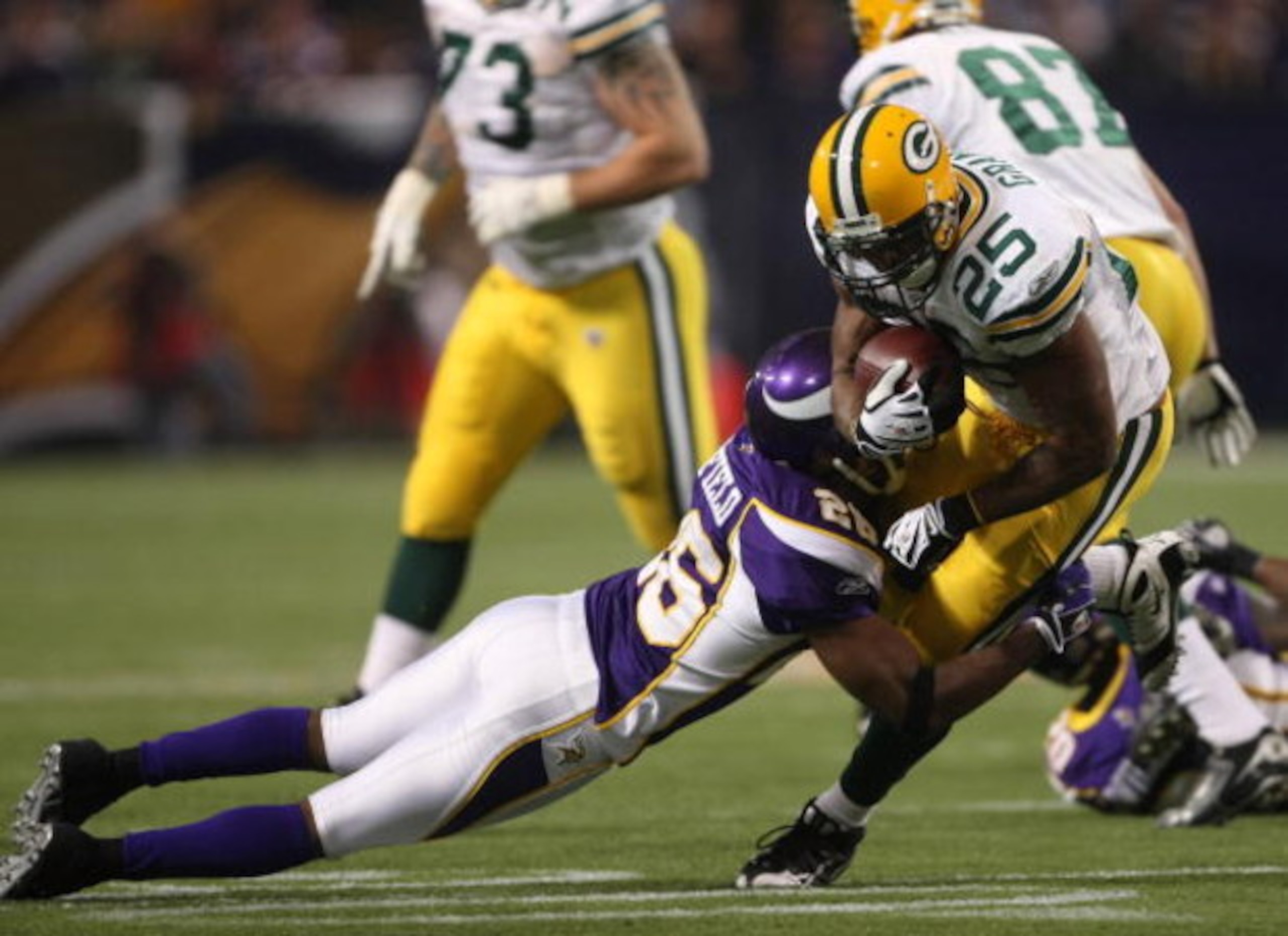 MINNEAPOLIS - NOVEMBER 09:  Running back Ryan Grant #25 of the Green Bay Packers carries the ball against cornerback Antoine Winfield #26 of the Minnesota Vikings on November 9, 2008 at the Metrodome in Mineapolis, Minnesota.  The Vikings won 28-27.  (Pho