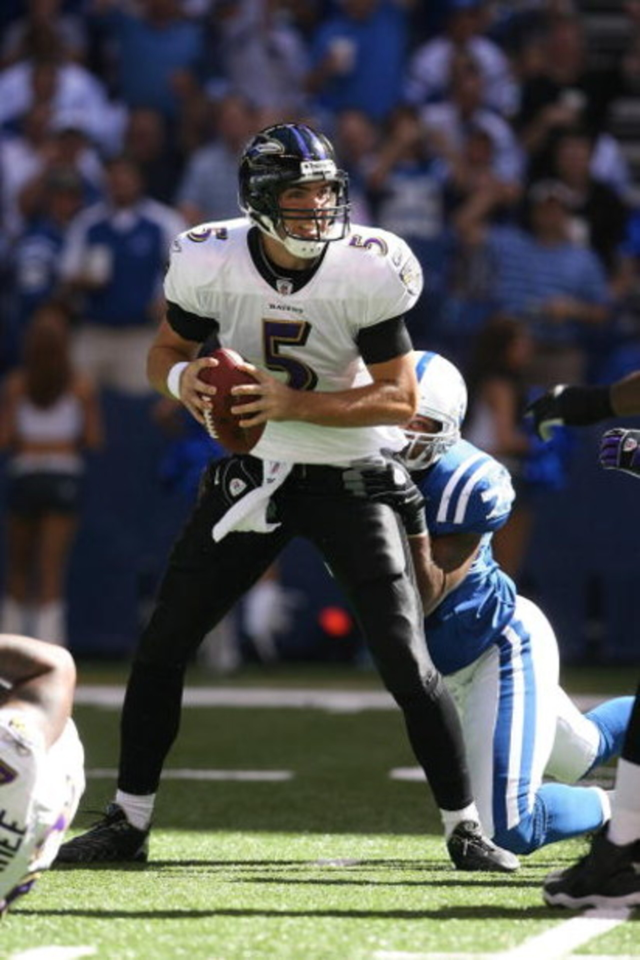 INDIANAPOLIS - OCTOBER 12:  Quarterback Joe Flacco #5 of the Baltimore Ravens looks to make a pass play as he's being tackled by Raheem Brock #79 of the Indianapolis Colts during the NFL game at Lucas Oil Stadium on October 12, 2008 in Indianapolis, India