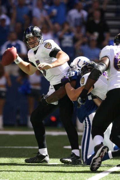 INDIANAPOLIS - OCTOBER 12:  Quarterback Joe Flacco #5 of the Baltimore Ravens looks to get rid of the ball as he's being tackled during the NFL game against the Indianapolis Colts at Lucas Oil Stadium on October 12, 2008 in Indianapolis, Indiana. The Colt