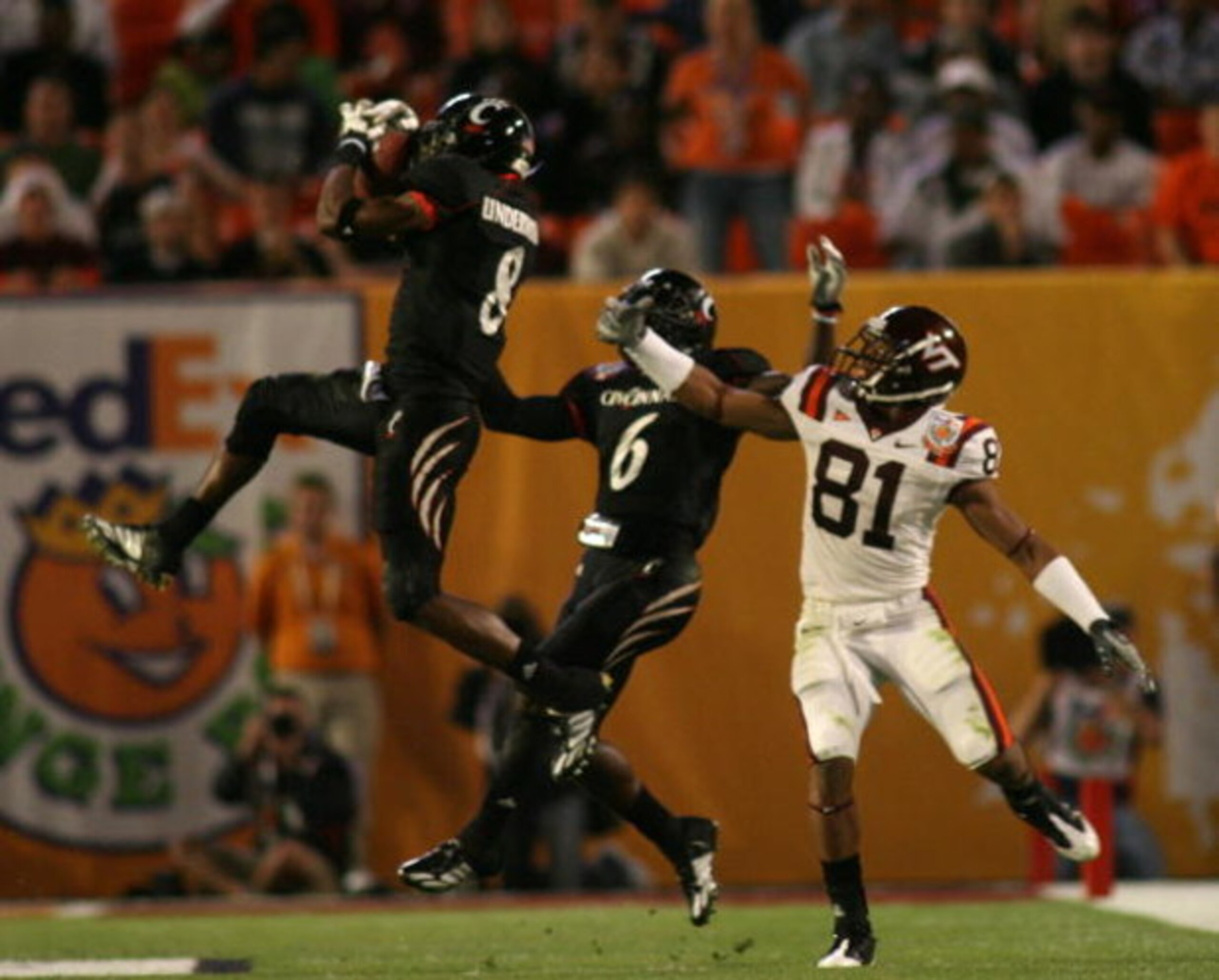 MIAMI - JANUARY 01:  Brandon Underwood #8 of the Cincinnati Bearcats makes an  interception against  Virginia Tech Hokies  as  Bearcats' DeAngelo Smith #6 and Hokies' Jarrett Boykin #81 look on during the FedEx Orange Bowl at Dolphin Stadium on January 1,