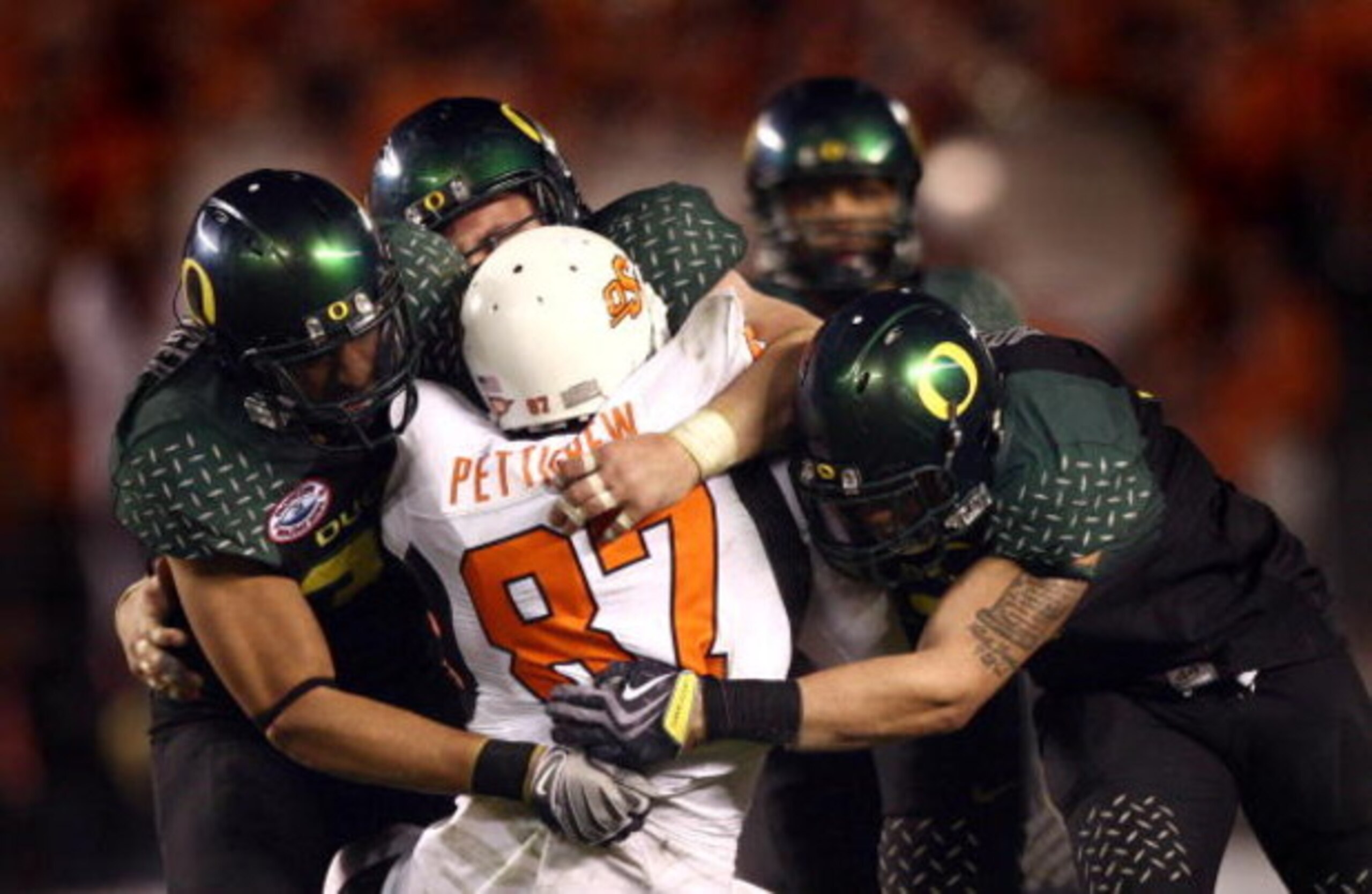 SAN DIEGO, CA - DECEMBER 30:   Tight End Brandon Pettigrew #87 of the Oklahoma State University Cowboys is tackled by the defense of the University of Oregon Ducks during the Ducks 42-31 win over the Cowboys in the Pacific Life Holiday Bowl at Qualcomm St
