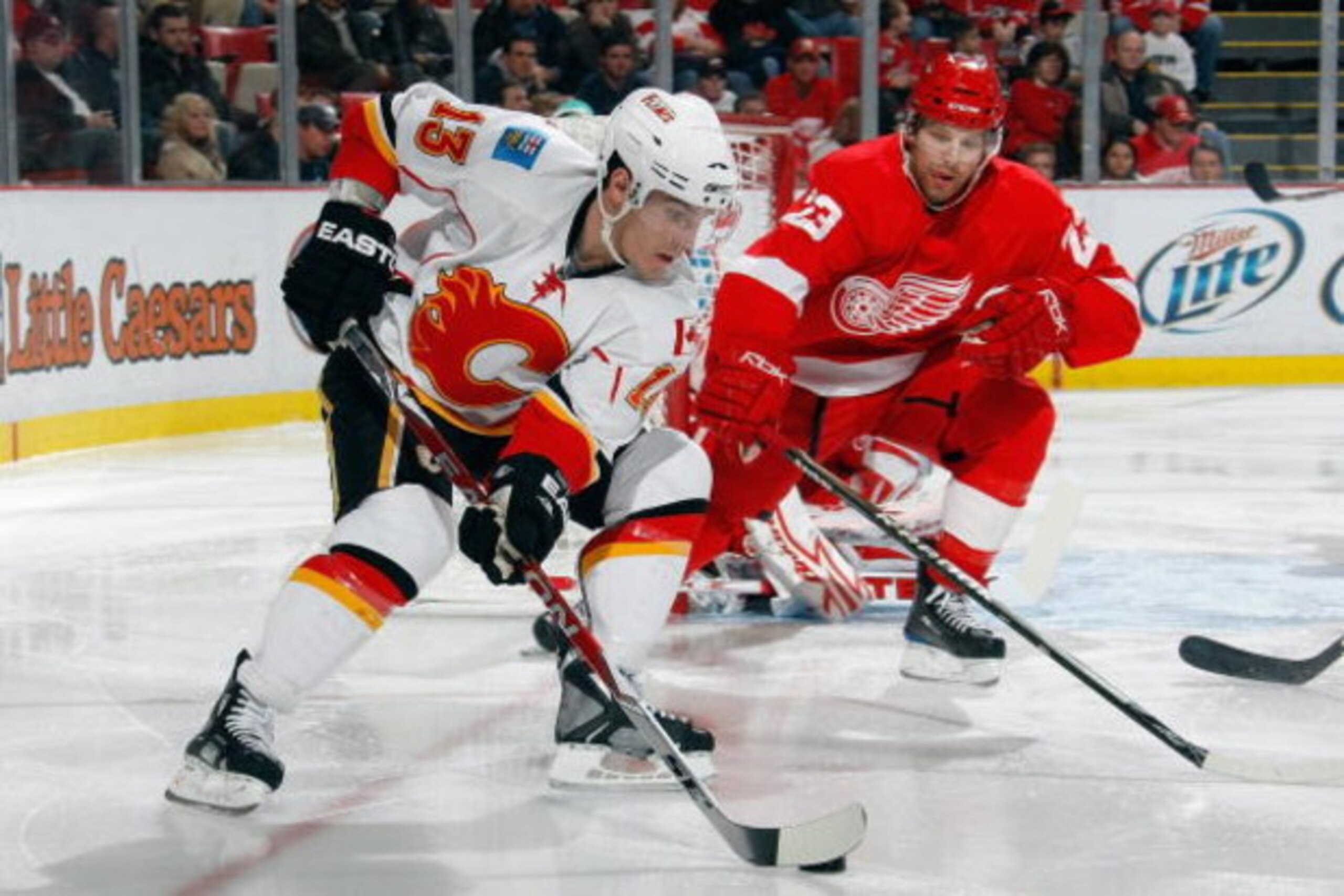 DETROIT - DECEMBER 10:  Mike Cammalleri #13 of the Calgary Flames skates with the puck against Brad Stuart #23 of the Detroit Red Wings at Joe Louis Arena December on 10, 2008 in Detroit, Michigan. (Photo by Dave Sandford/Getty Images)