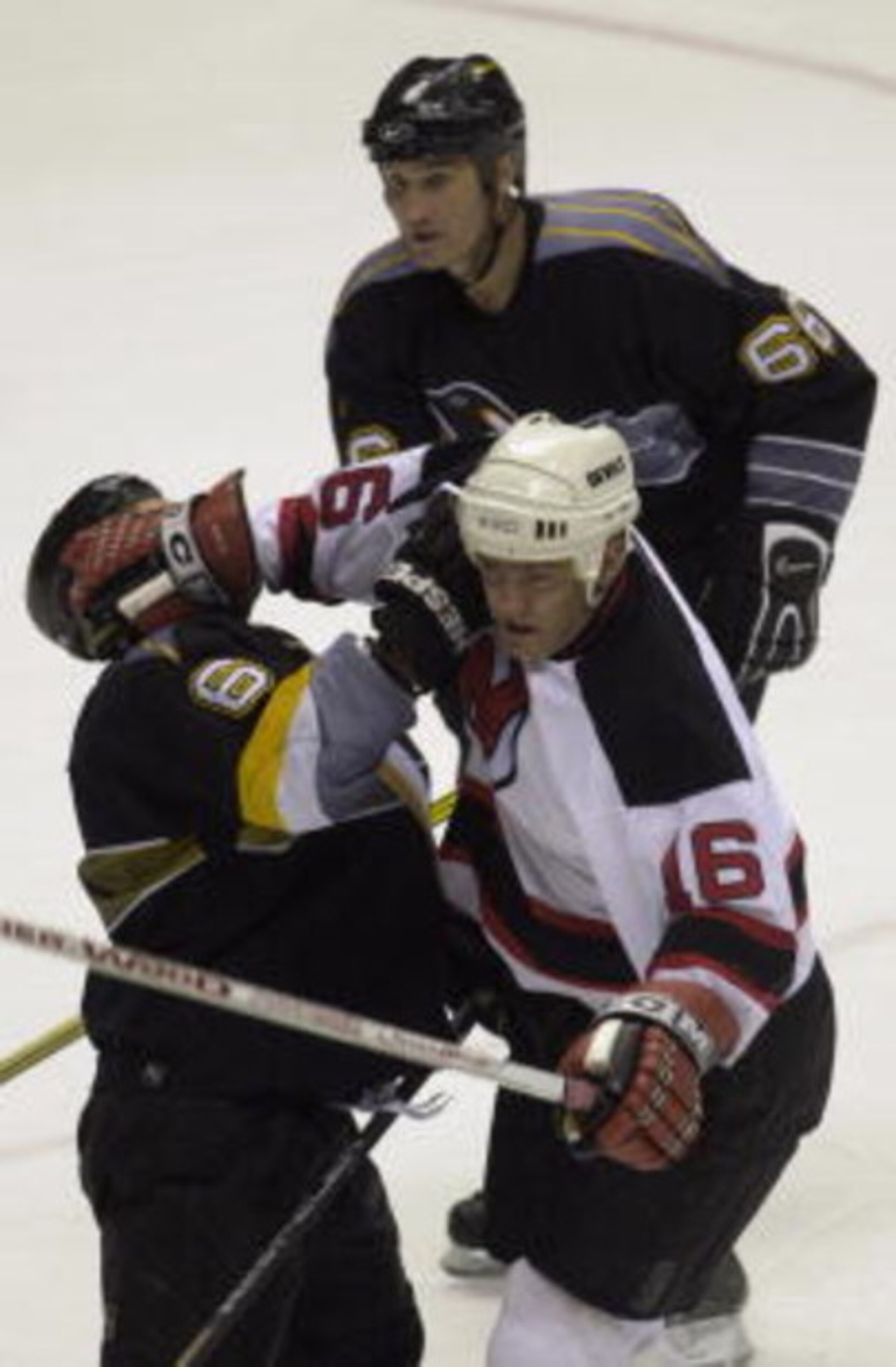 15 May 2001:  Bobby Holik #16 of the New Jersey Devils and Bob Boughner #6 of the Pittsburgh Penguins collide as Mario Lemieux #66 follows the play in game two of the Eastern Conference Finals of the 2001 Stanley Cup Playoffs at the Continental Airlines A