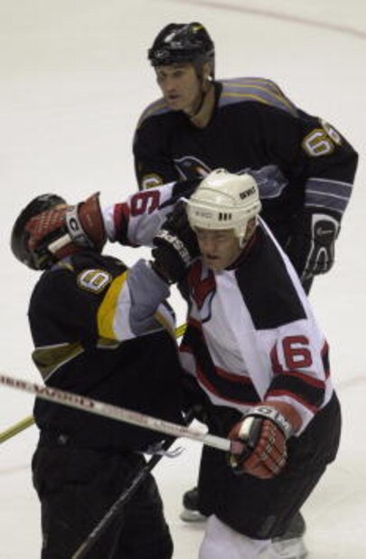 15 May 2001:  Bobby Holik #16 of the New Jersey Devils and Bob Boughner #6 of the Pittsburgh Penguins collide as Mario Lemieux #66 follows the play in game two of the Eastern Conference Finals of the 2001 Stanley Cup Playoffs at the Continental Airlines A