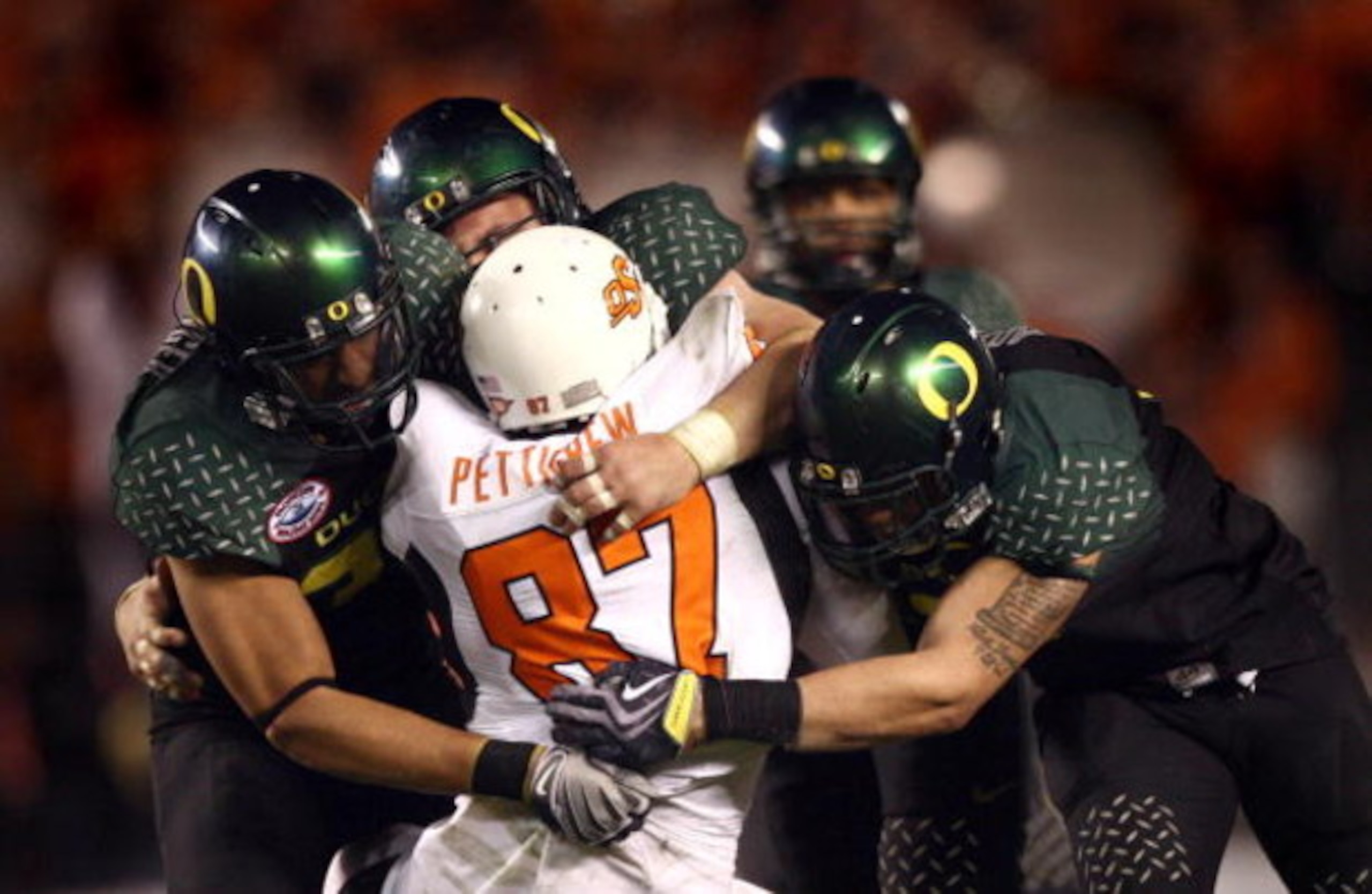 SAN DIEGO, CA - DECEMBER 30:   Tight End Brandon Pettigrew #87 of the Oklahoma State University Cowboys is tackled by the defense of the University of Oregon Ducks during the Ducks 42-31 win over the Cowboys in the Pacific Life Holiday Bowl at Qualcomm St