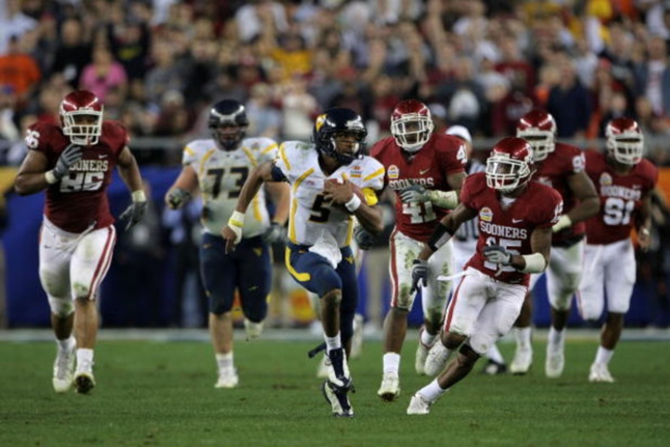 GLENDALE, AZ - JANUARY 02:  Quarterback Patrick White #5 of the West Virginia Mountaineers runs for 47-yards past Dominique Franks #15 of the Oklahoma Sooners in the second half at the Tostito's Fiesta Bowl at University of Phoenix Stadium January 2, 2008