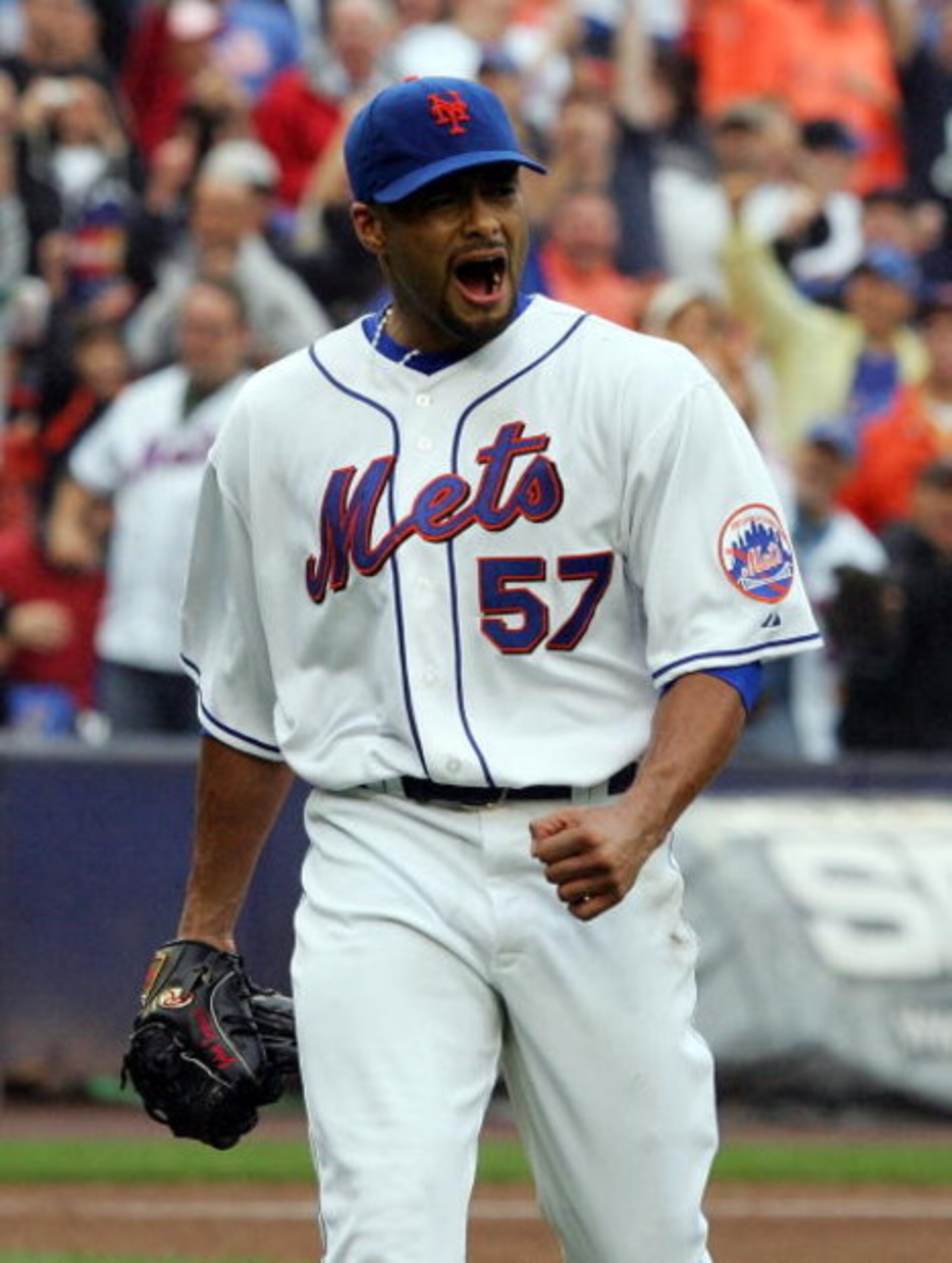 NEW YORK - SEPTEMBER 27:  Johan Santana #57 of the New York Mets celebrates the final out of the eigth inning against the Florida Marlins on September 27, 2008 at Shea Stadium in the Flushing neighborhood of the Queens borough of New York City. The Mets d