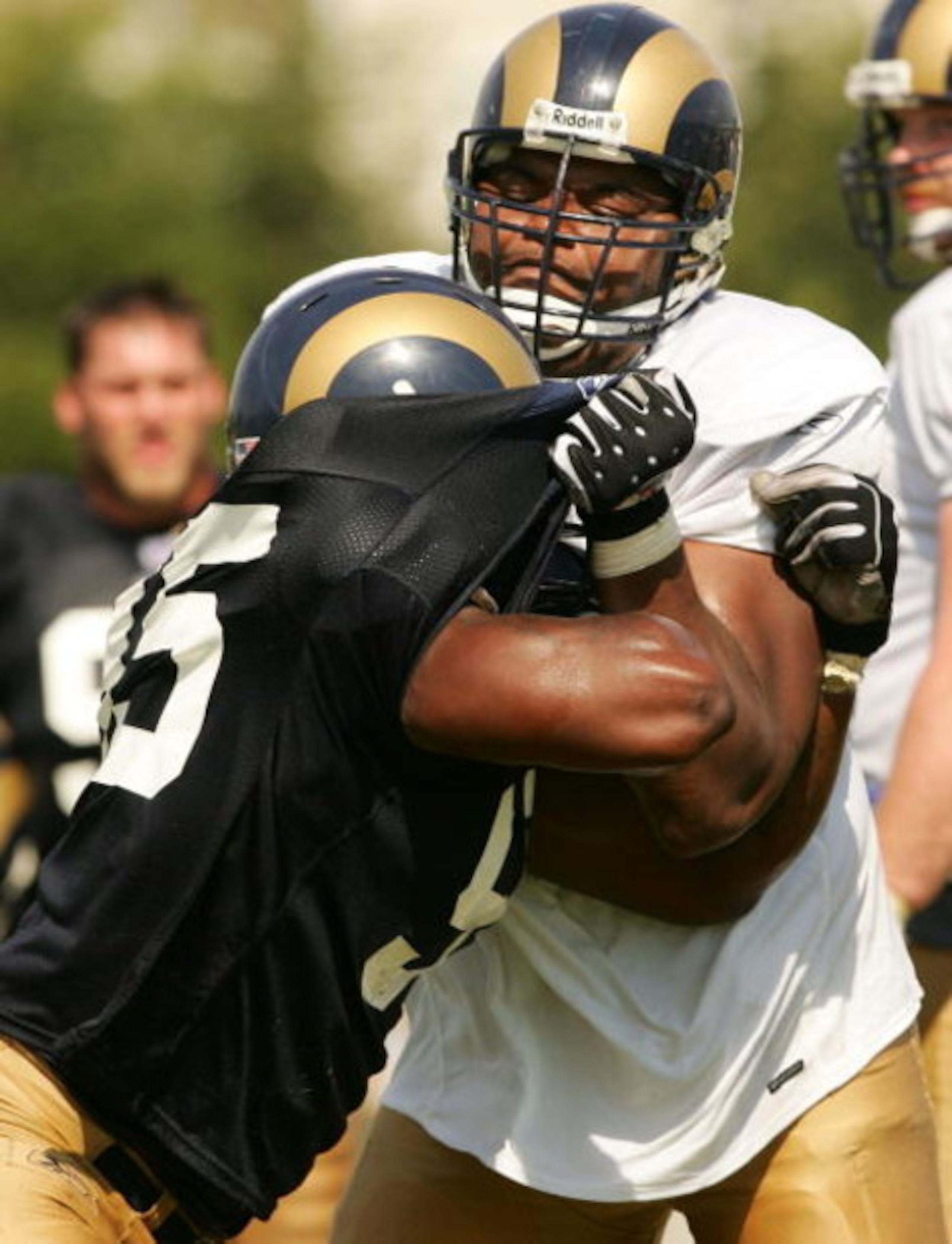 EARTH CITY, MO - JULY 29:  Orlando Pace #76 of the St. Louis Rams shoves teammate Anthony Hargrove #95 in a drill during St. Louis Rams Training Camp July 29, 2005 at Rams Park in Earth City, Missouri.  (Photo by Elsa/Getty Images)