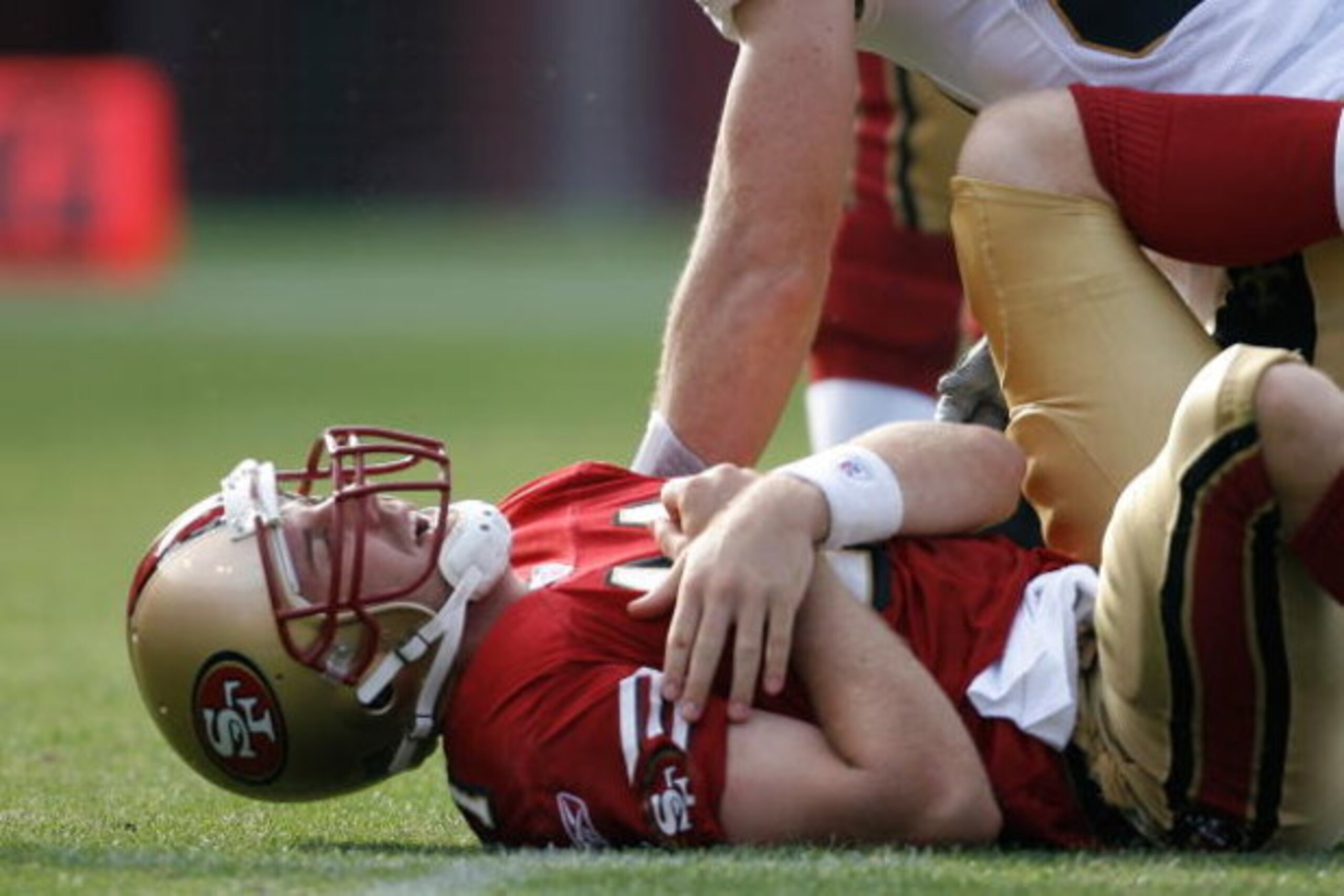 SAN FRANCISCO - OCTOBER 28:  Quarterback Alex Smith #11 of the San Francisco 49ers grimaces in pain and reaches for his shoulder during a game against the New Orleans Saints at Monster Park October 28, 2007 in San Francisco, California. New Orleans won 31