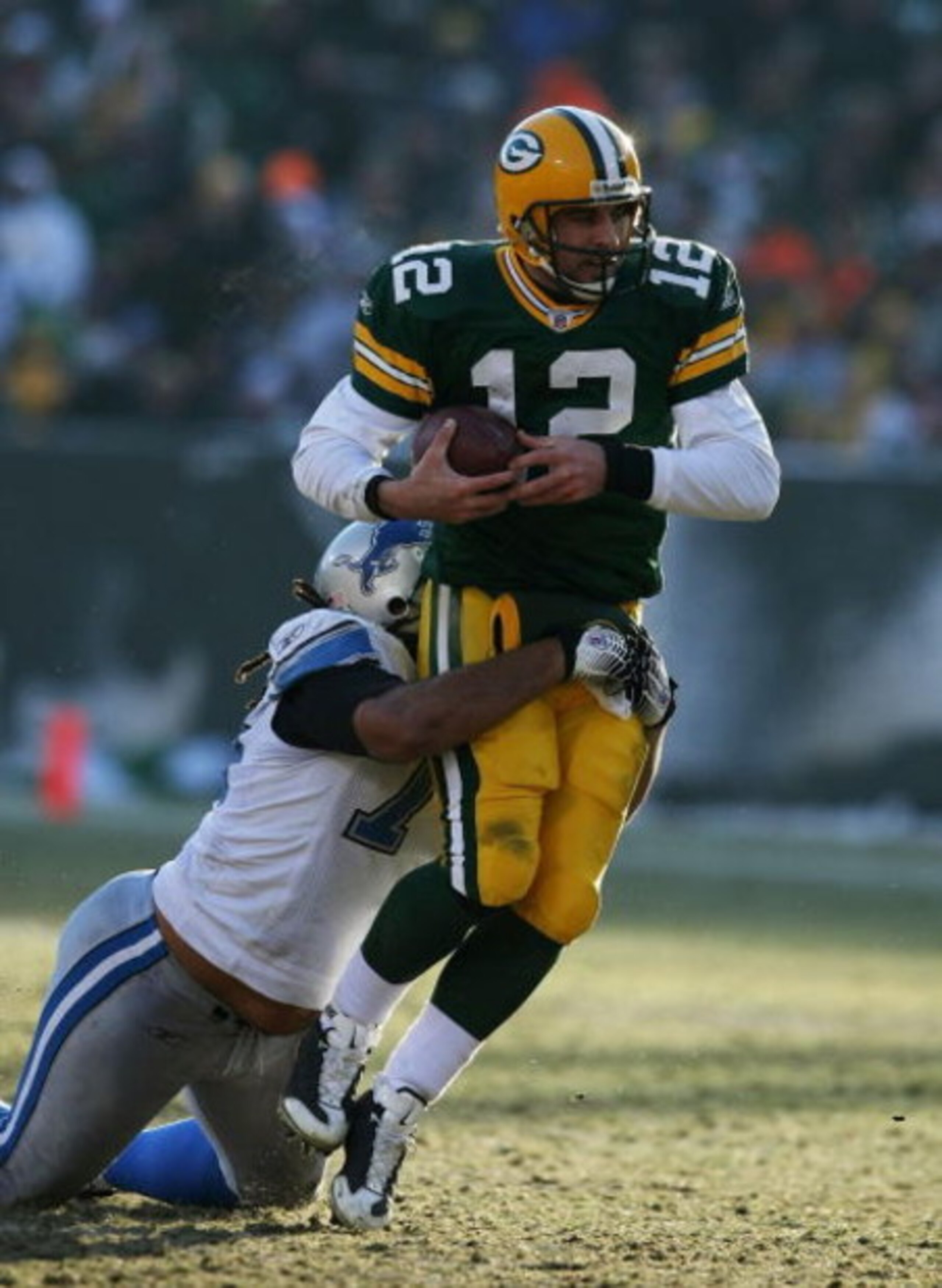 GREEN BAY, WI - DECEMBER 28: Aaron Rodgers #12 of the Green Bay Packers is brought down by Ikaika Alamam-Francis #97 of the Detroit Lions on December 28, 2008 at Lambeau Field in Green Bay, Wisconsin. The Packers defeated the Lions 31-21. (Photo by Jonath