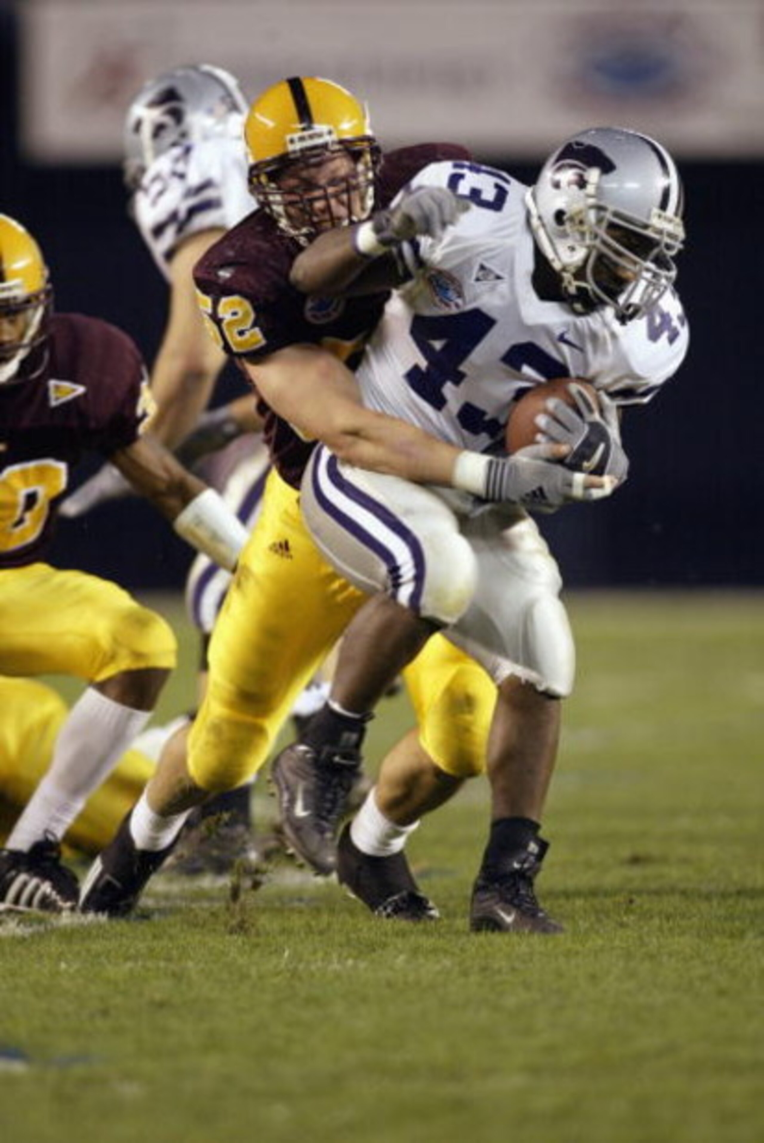 SAN DIEGO - DECEMBER 27:  Darren Sproles #43 of Kansas State drags Mason Unck #52 of Arizona State during the first quarter of the Pacific Life Holiday Bowl at Qualcomm Stadium on December 27, 2002 in San Diego, California.  The Wildcats defeated the Sun 
