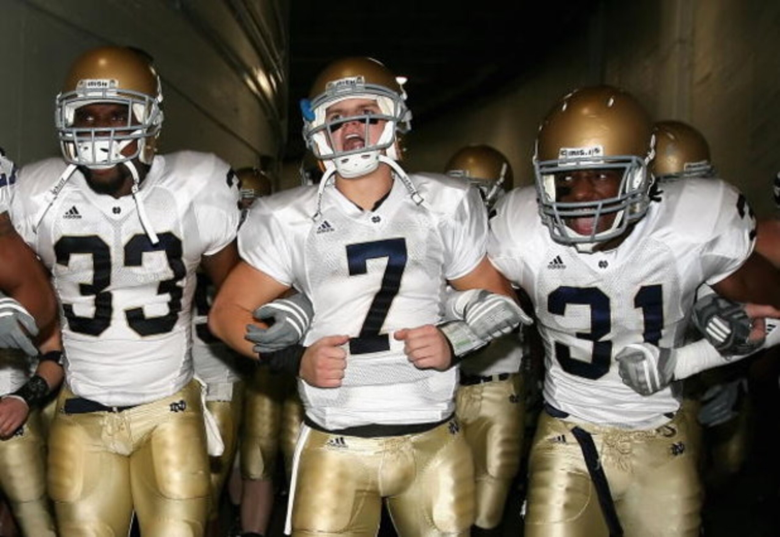 LOS ANGELES, CA - NOVEMBER 29:  Quarterback Jimmy Clausen #7 of the Notre Dame Fighting Irish walks out with teammates Robert Hughes #33 and Sergio Brown #31 before the game against the USC Trojans at Los Angeles Memorial Coliseum on November 29, 2008 in 