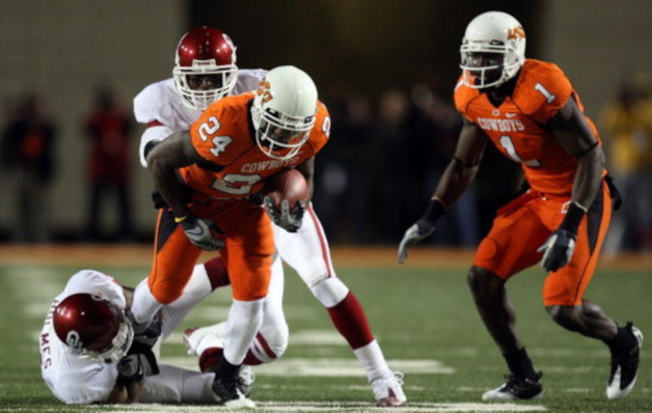 STILLWATER, OK - NOVEMBER 29:  Running back Kendall Hunter #24 of the Oklahoma State Cowboys runs the ball against Lendy Holmes #11 of the Oklahoma Sooners at Boone Pickens Stadium on November 29, 2008 in Stillwater, Oklahoma.  (Photo by Ronald Martinez/G