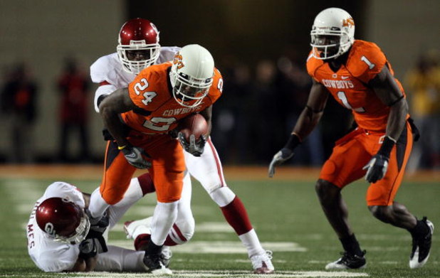 STILLWATER, OK - NOVEMBER 29:  Running back Kendall Hunter #24 of the Oklahoma State Cowboys runs the ball against Lendy Holmes #11 of the Oklahoma Sooners at Boone Pickens Stadium on November 29, 2008 in Stillwater, Oklahoma.  (Photo by Ronald Martinez/G