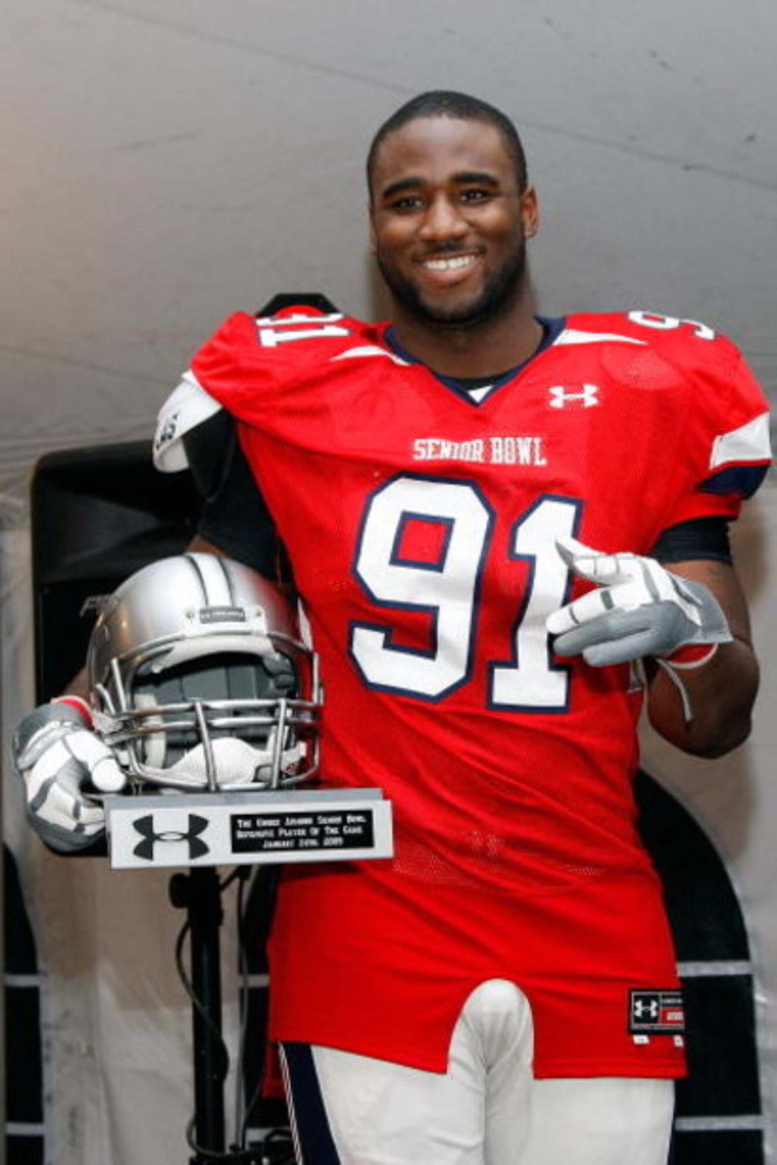 MOBILE, AL - JANUARY 24: Robert Ayers #91 of the South Team accepts the Defensive Player of the game Trophy after defeating the North Team during the Under Armour Senior Bowl on January 24, 2009 at Ladd-Peebles Stadium in Mobile, Alabama. (Photo by Chris MOBILE, AL - JANUARY 24: Robert Ayers #91 of the South Team accepts the Defensive Player of the game Trophy after defeating the North Team during the Under Armour Senior Bowl on January 24, 2009 at Ladd-Peebles Stadium in Mobile, Alabama. (Photo by Chris