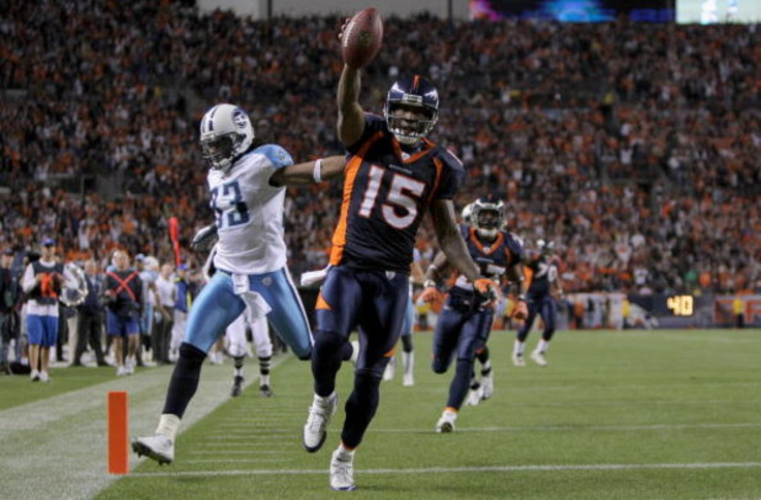 DENVER - NOVEMBER 19:  Wide receiver Brandon Marshall #15 of the Denver Broncos begins to celebrate as he beats safety Michael Griffin #33 of the Tennessee Titans to the enzone as he goes 41 yards on a reception from Jay Cutler #6 of the Denver Broncos fo