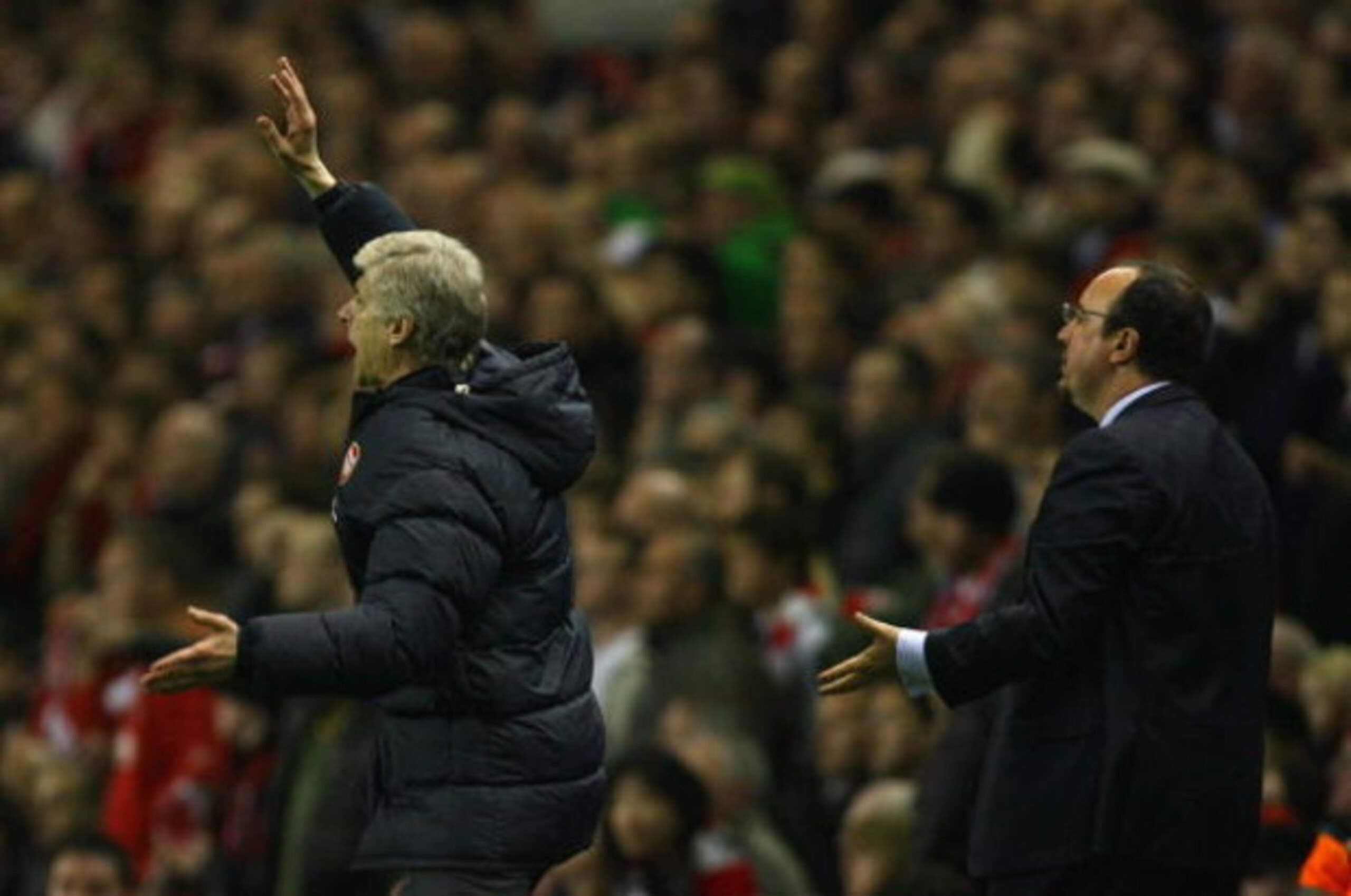 LIVERPOOL, UNITED KINGDOM - APRIL 21:  Arsenal Manager Arsene Wenger (L) and Liverpool Manager Rafael Benitez gesture to their players during the Barclays Premier League match between Liverpool and Arsenal at Anfield on April 21, 2009 in Liverpool, Englan