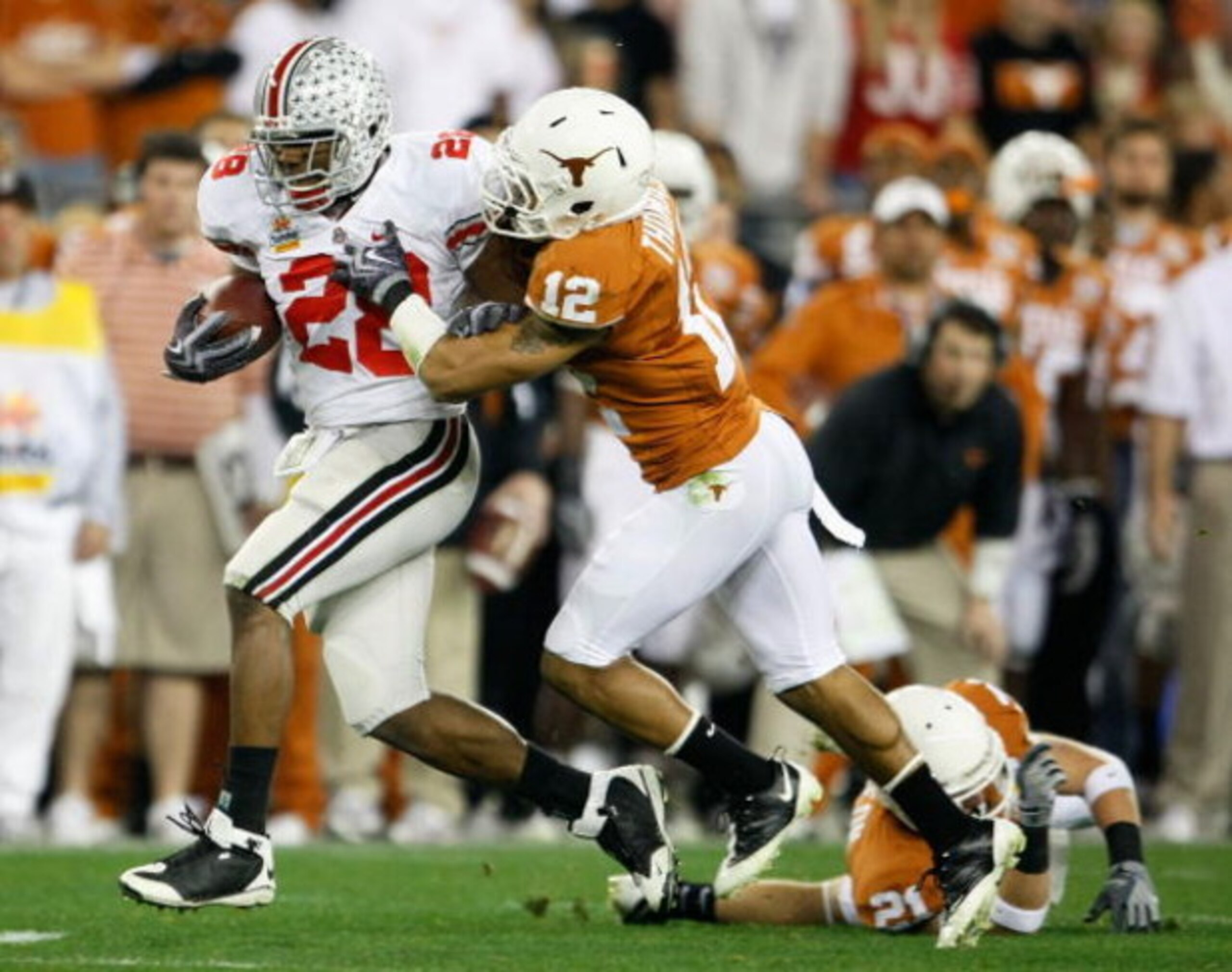 GLENDALE, AZ - JANUARY 05: Runningback Chris Wells #28 of the Ohio State Buckeyes rushes the ball under pressure from Earl Thomas #12 of the Texas Longhorns during the Tostitos Fiesta Bowl Game on January 5, 2009 at University of Phoenix Stadium in Glend GLENDALE, AZ - JANUARY 05: Runningback Chris Wells #28 of the Ohio State Buckeyes rushes the ball under pressure from Earl Thomas #12 of the Texas Longhorns during the Tostitos Fiesta Bowl Game on January 5, 2009 at University of Phoenix Stadium in Glend