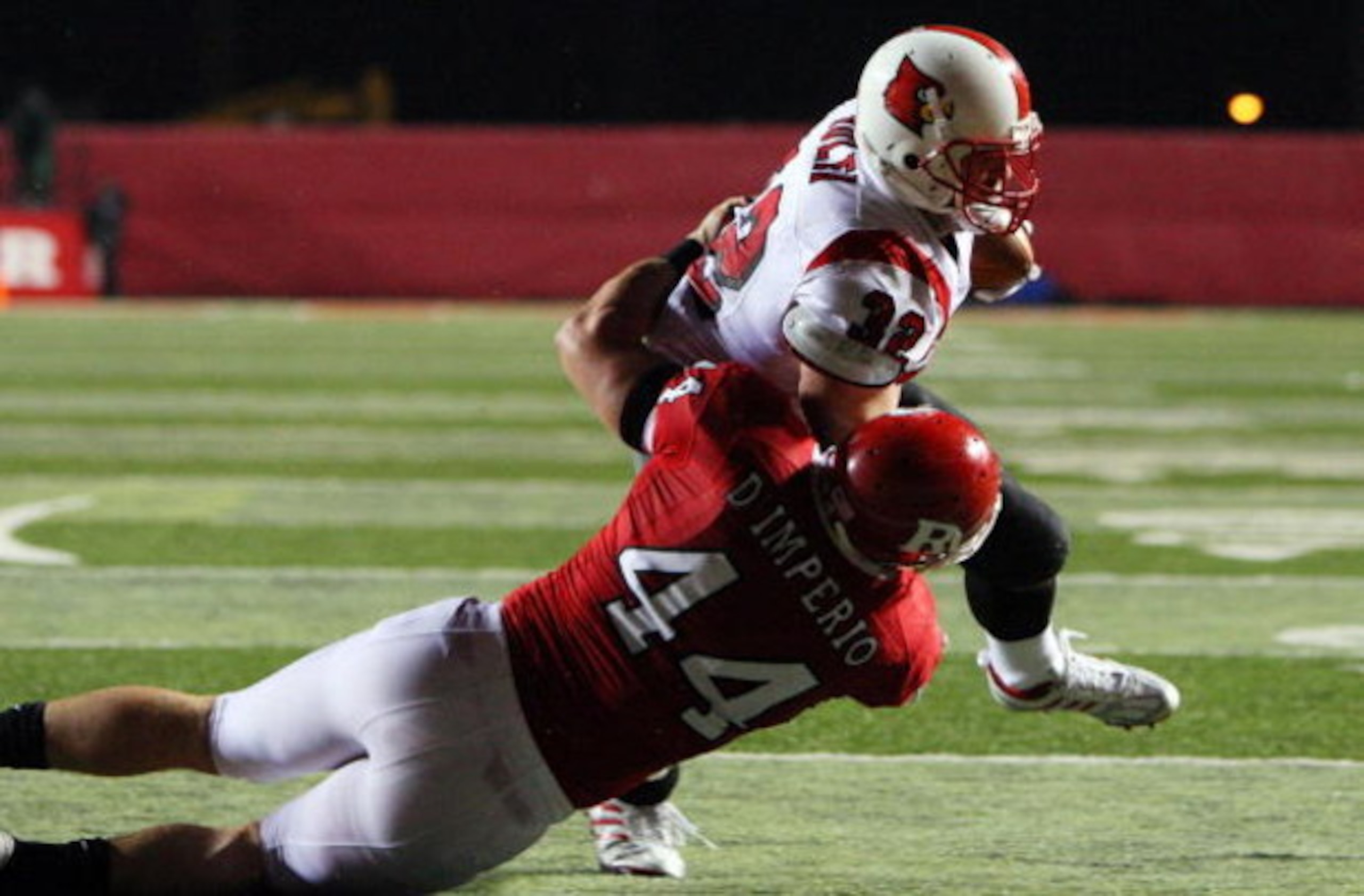 PISCATAWAY, NJ - DECEMBER 04: Brock Bolen #32 of the Louisville Cardinals runs in a fourth quarter touchdown against Ryan D'Imperio of the Rugers Scarlet Knights at Rutgers Stadium on December 4, 2008 in Piscataway, New Jersey. (Photo by Jim McIsaac/Getty