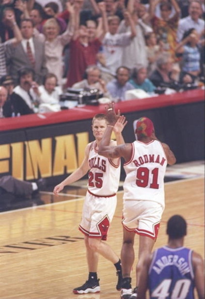 13 Jun 1997: Guard Shandon Anderson of the Utah Jazz watches as guard Steve Kerr #25 and forward Dennis Rodman #91 of the Chicago Bulls high five each other during game 6 of the 1997 NBA Finals at the United Center in Chicago, Illinois. The Bulls defeated