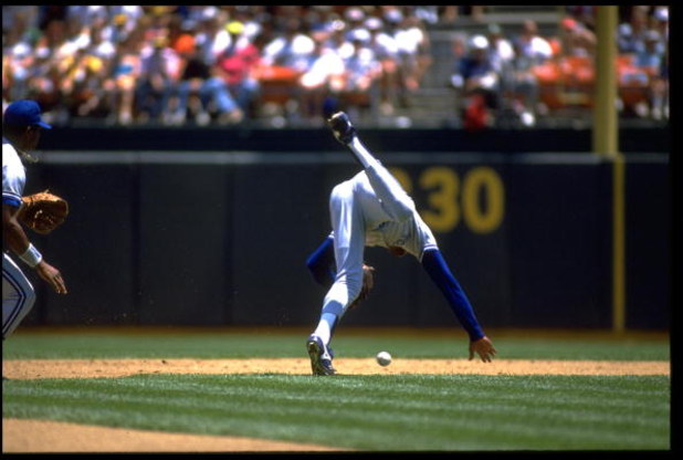 TONY FERNANDEZ, SHORTSTOP FOR THE TORONTO BLUE JAYS, STUMBLES WHILE ATTEMPTING TO PICK UP A GROUND BALL DURING THEIR GAME AGAINST THE OAKLAND A''S AT THE OAKLAND COLISEUM IN OAKLAND, CALIFORNIA. MANDATORY CREDIT: OTTO GREULE/ALLSPORT