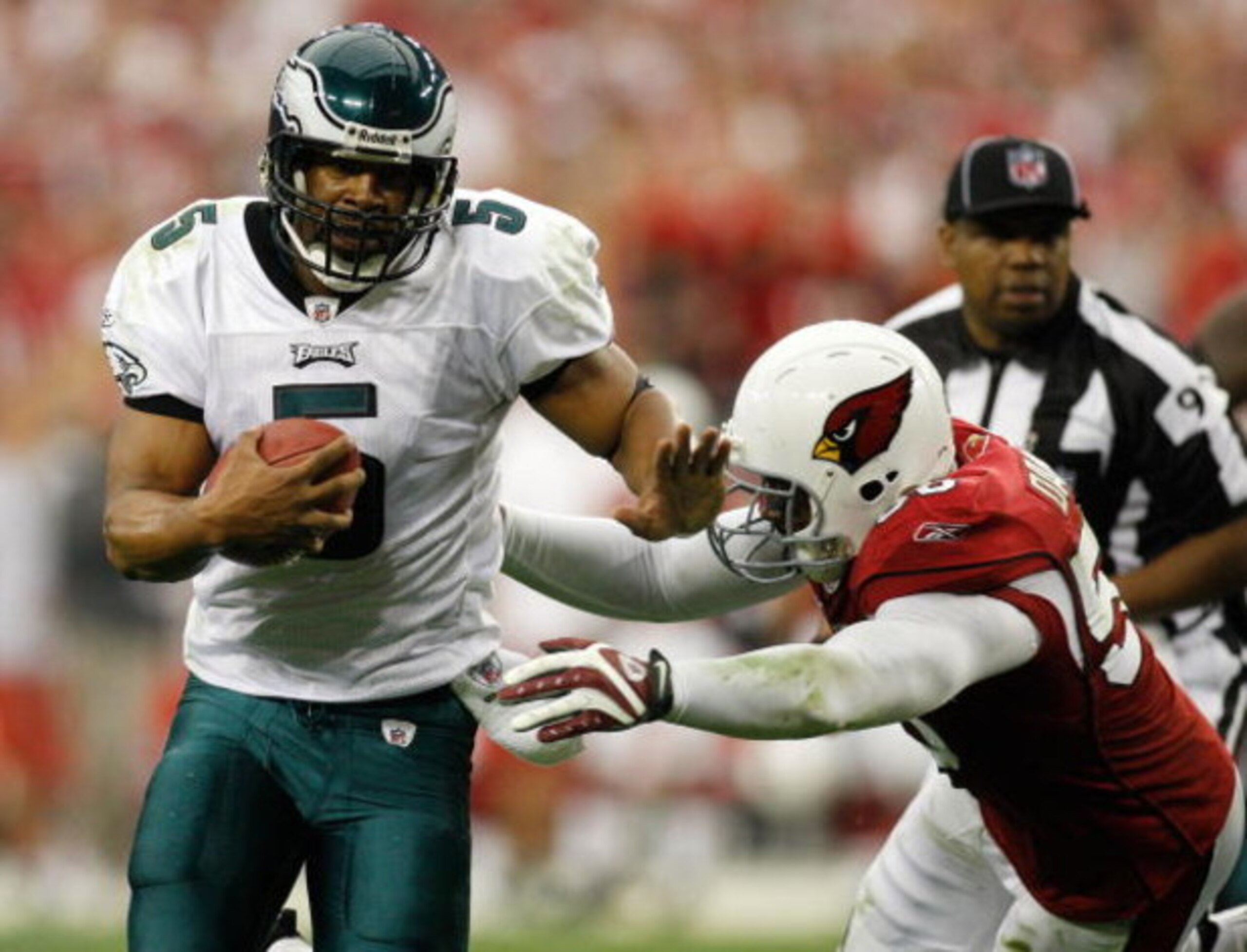 GLENDALE, AZ - JANUARY 18:  Quarterback Donovan McNabb #5 of the Philadelphia Eagles rushes with the ball as linebacker Karlos Dansby#58 of the Arizona Cardinals dives to tackle him during the NFC championship game on January 18, 2009 at University of Pho