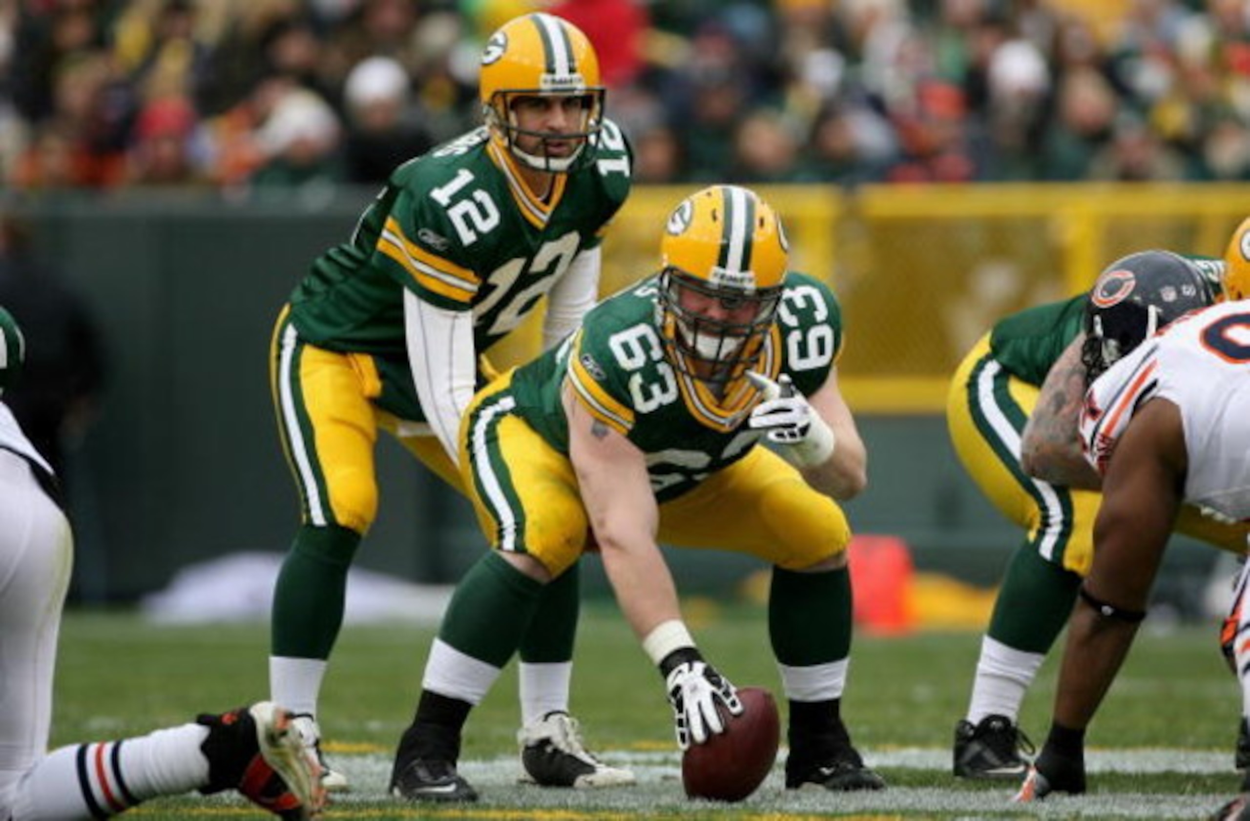 GREEN BAY, WI - NOVEMBER 16:  Center Scott Wells #63 prepares to snap the ball to quarterback Aaron Rodgers #12 of the Green Bay Packers against the Chicago Bears during NFL action at Lambeau Field on November 16, 2008 in Green Bay, Wisconsin. The Packers