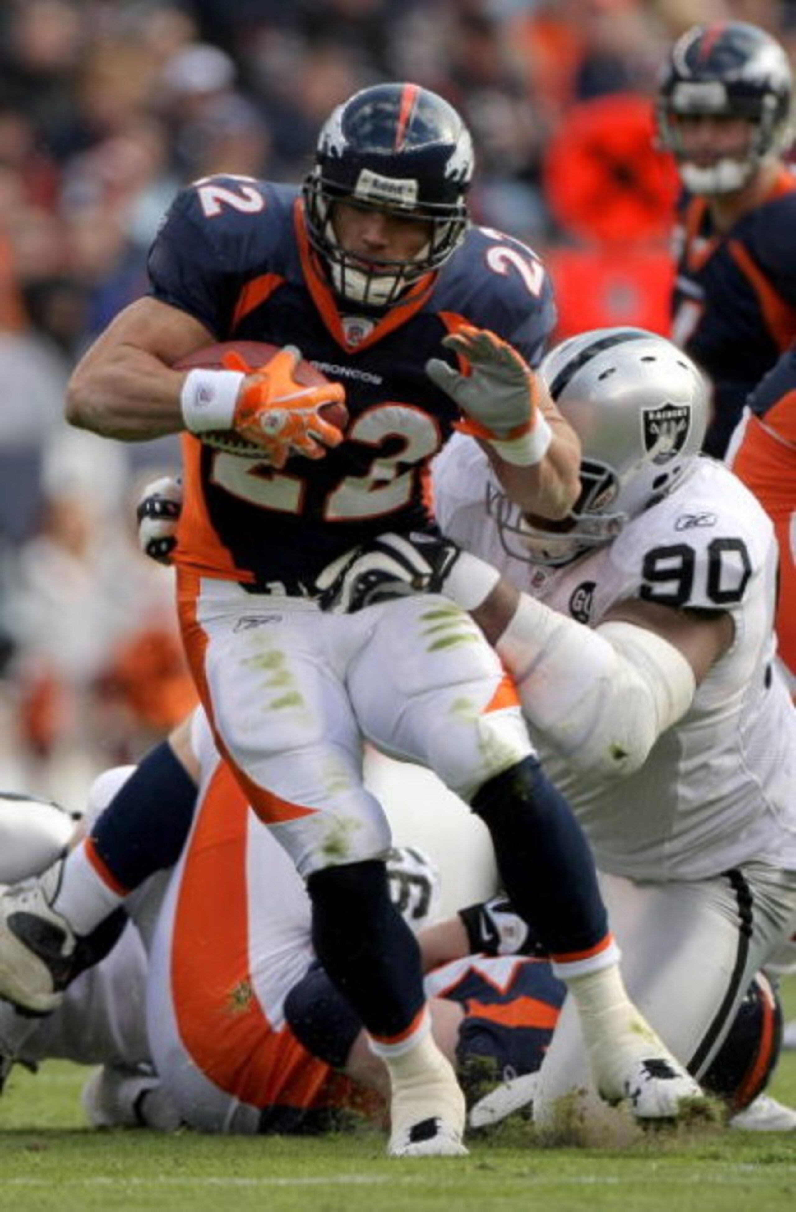 DENVER - NOVEMBER 23:  Peyton Hillis #22 of the Denver Broncos breaks a tackle by Terdell Sands #90 of the Oakland Raiders during week 12 NFL action at Invesco Field at Mile High on November 23, 2008 in Denver, Colorado. The Raiders defeated the Broncos 3