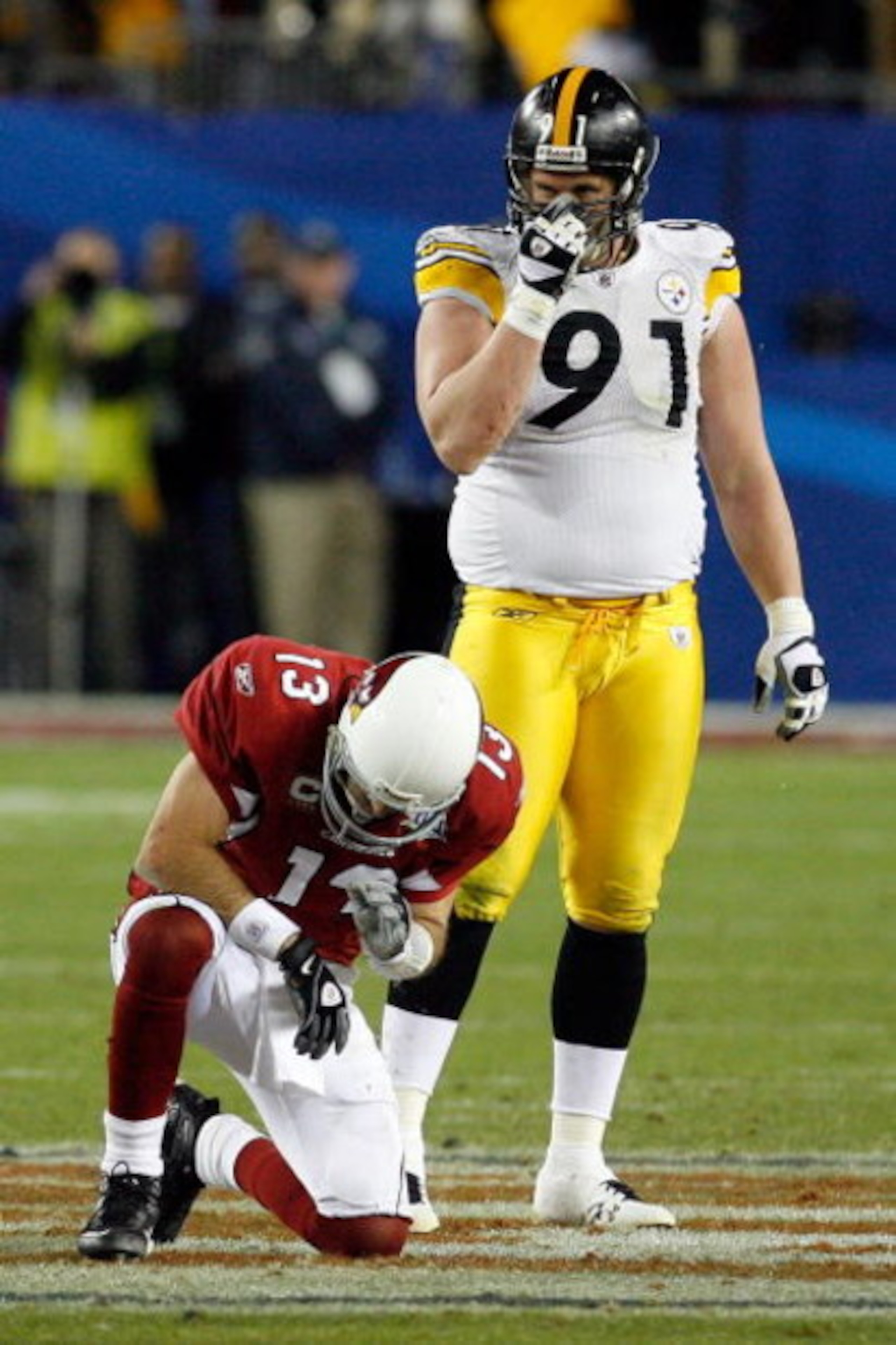 TAMPA, FL - FEBRUARY 01:  Quarterback #13 of the Arizona Cardinals kneels on the field after he was hit on a play in the fourth quarter as Aaron Smith #91 of the Pittsburgh Steelers looks on during Super Bowl XLIII on February 1, 2009 at Raymond James Sta