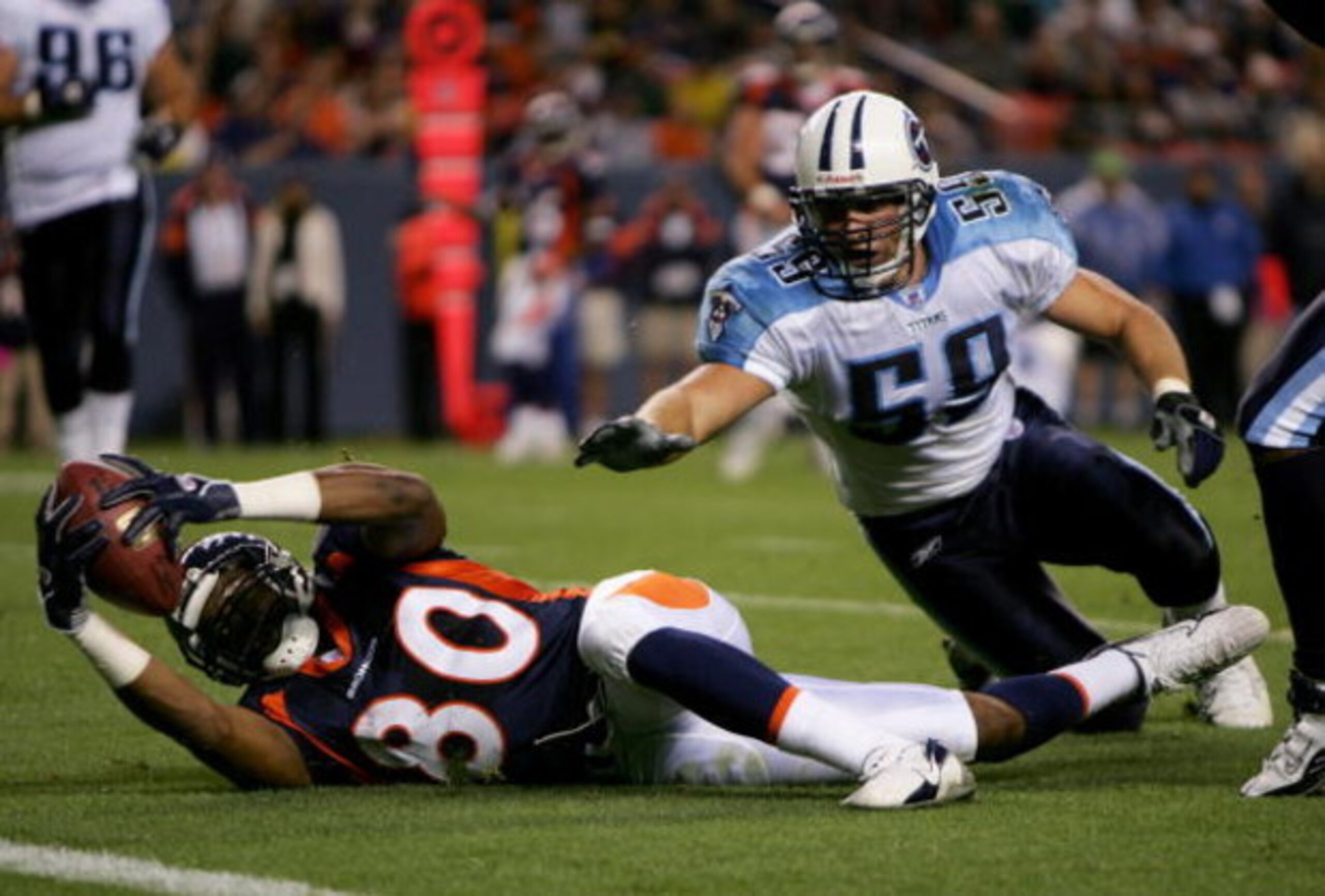 DENVER - AUGUST 19:  Rod Smith #80 of the Denver Broncos goes down on the 1 yard line on a 12 yard pass from Jake Plummer after breaking a tackle by Peter Sirmon #59 of the Tennessee Titans during preseason NFL action on August 19, 2006 at Mile High Stadi