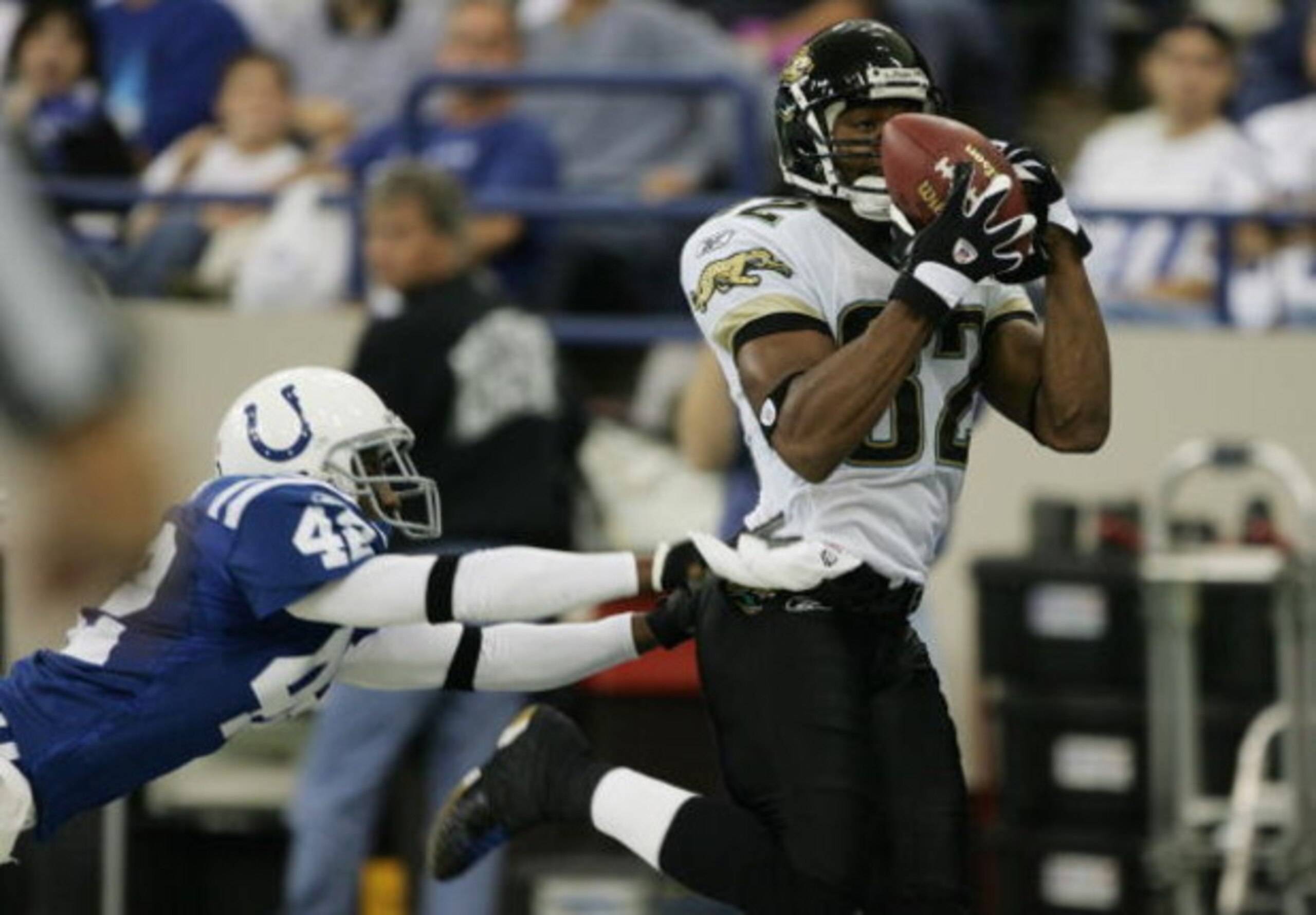 INDIANAPOLIS - OCTOBER 24:  Wide receiver Jimmy Smith #82 of the Jacksonville Jaguars evades defensive back Jason David #42 of the Indianapolis Colts during the game on October 24, 2004 at the RCA Dome in Indianapolis, Indiana. The Jaguars defeated the Co