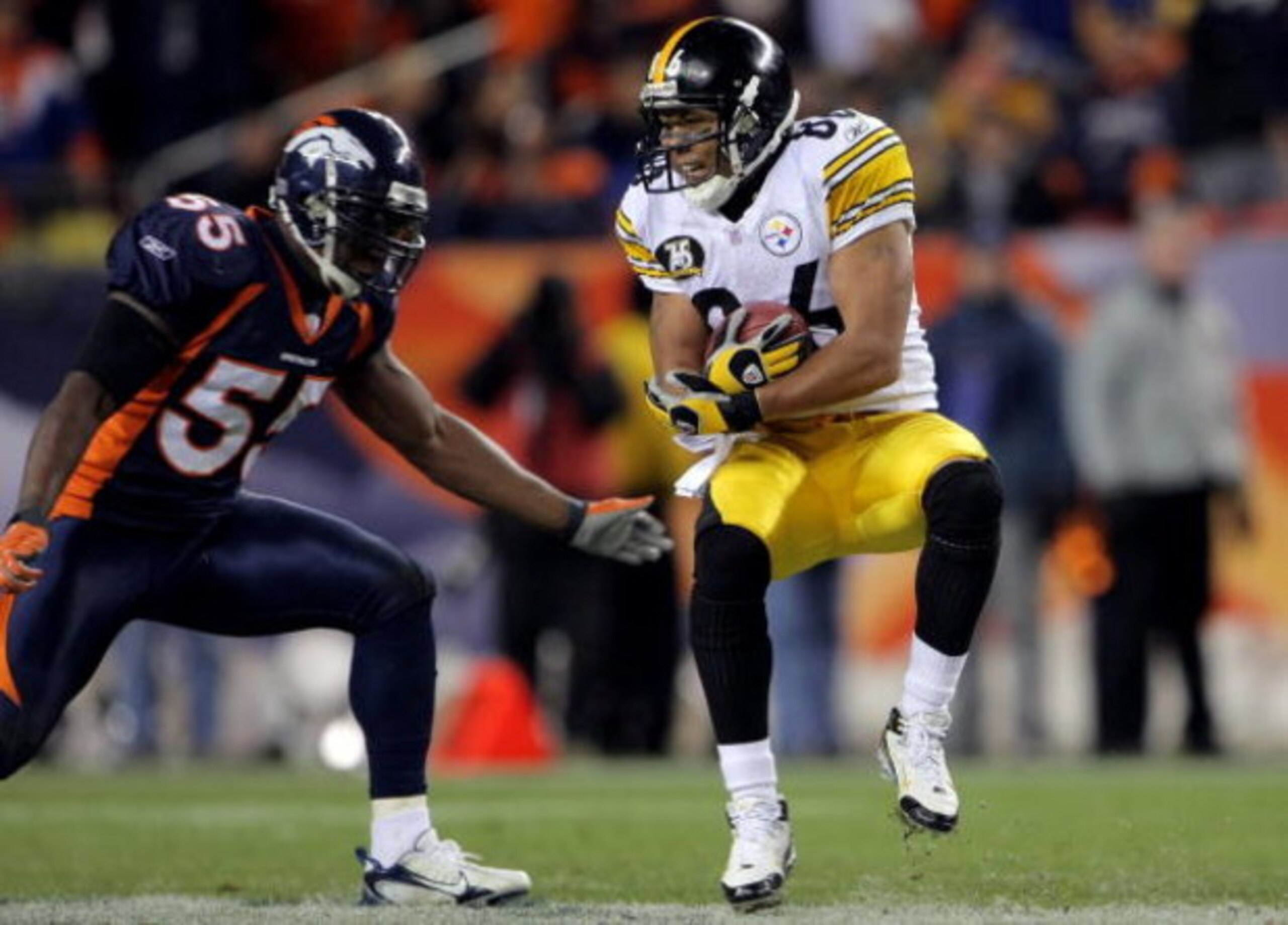 DENVER - OCTOBER 21:  Hines Ward #86 of the Pittsburgh Steelers makes a reception as D.J. Williams #55 of the Denver Broncos defends at Invesco Field at Mile High on October 21, 2007 in Denver, Colorado. The Broncos defeated the Steelers 31-28.  (Photo by