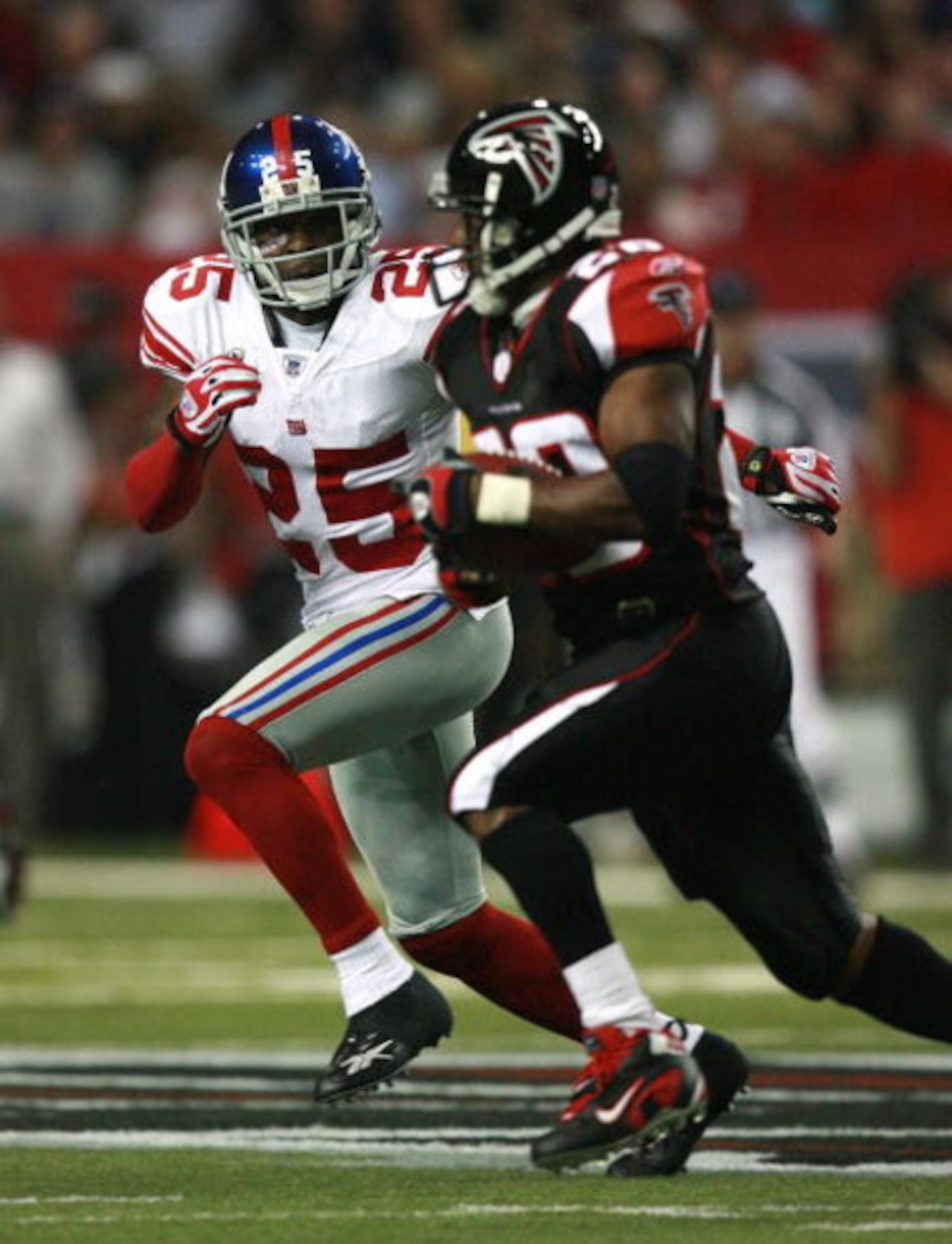 ATLANTA - OCTOBER 15: Cornerback R.W. McQuarters #25 of the New York Giants tries to run down running back Warrick Dunn #28 of the Atlanta Falcons at Georgia Dome on October 15, 2007 in Atlanta, Georgia. The Giants defeated the Falcons 31-10 for their fou