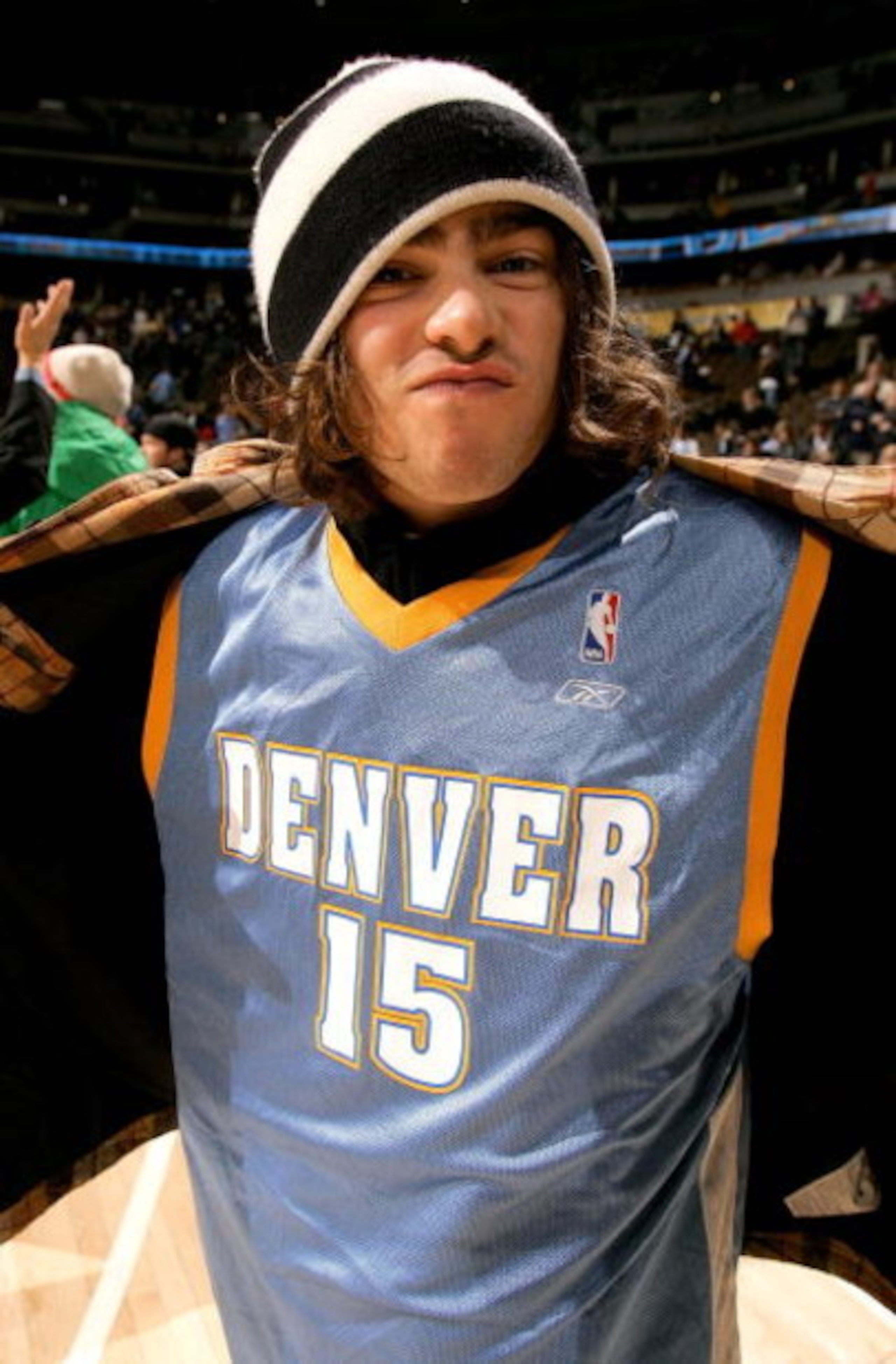 DENVER - DECEMBER 18:  Professional snowboarder Danny Davis puts on his jacket as he leaves his courtside seat wearing the #15 jersey of suspended Carmelo Anthony after the Denver Nuggets defeated the Washington Wizards 117-108 during NBA on December 18, 