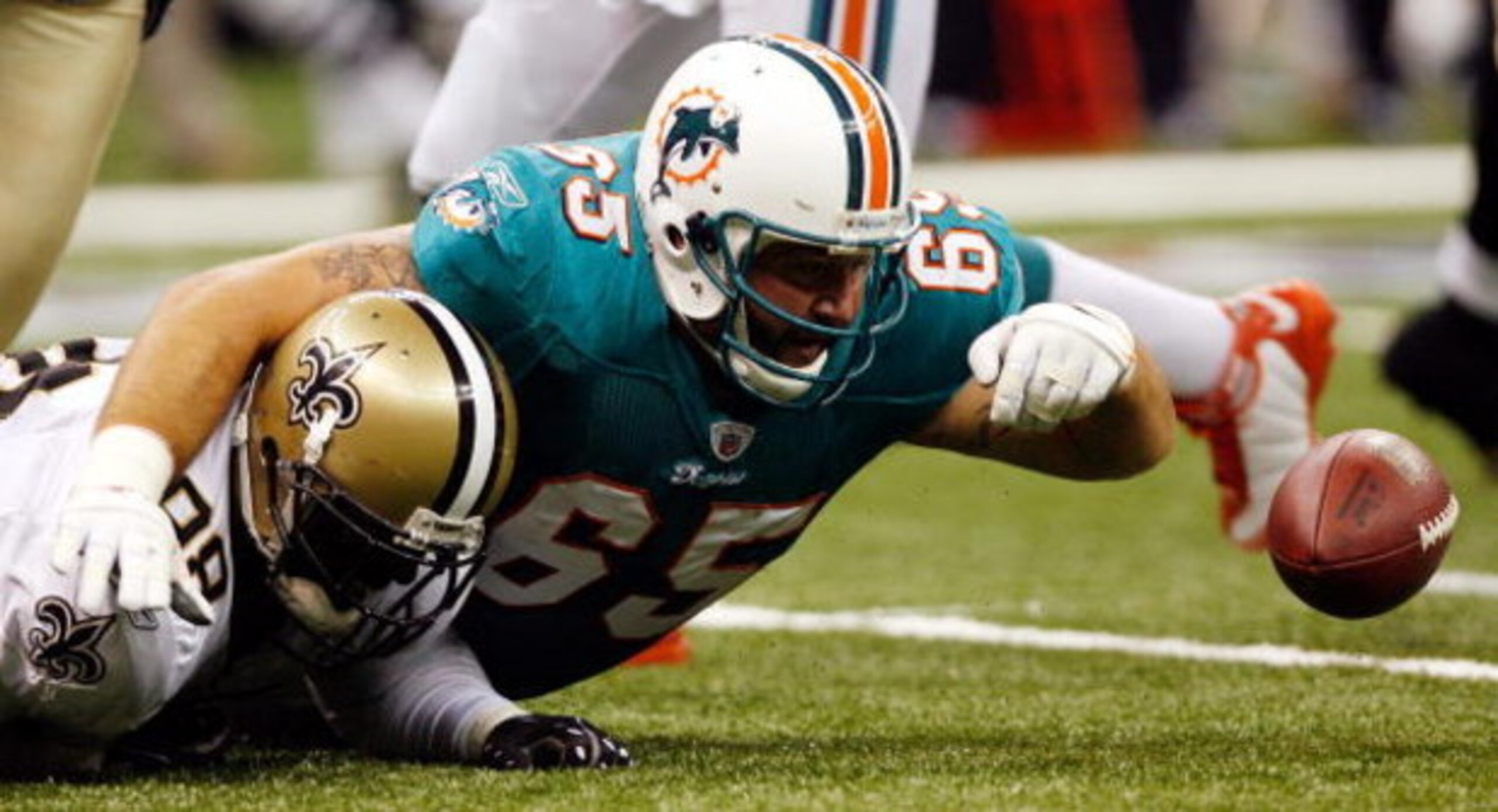 NEW ORLEANS - AUGUST 28:  Miami Dolphins guard Justin Smiley #65 scrambles for a fumble with New Orleans Saints defensive end Sedrick Ellis #98 during the second quarter of their final preseason game at the Louisiana Superdome on August 28, 2008 in New Or