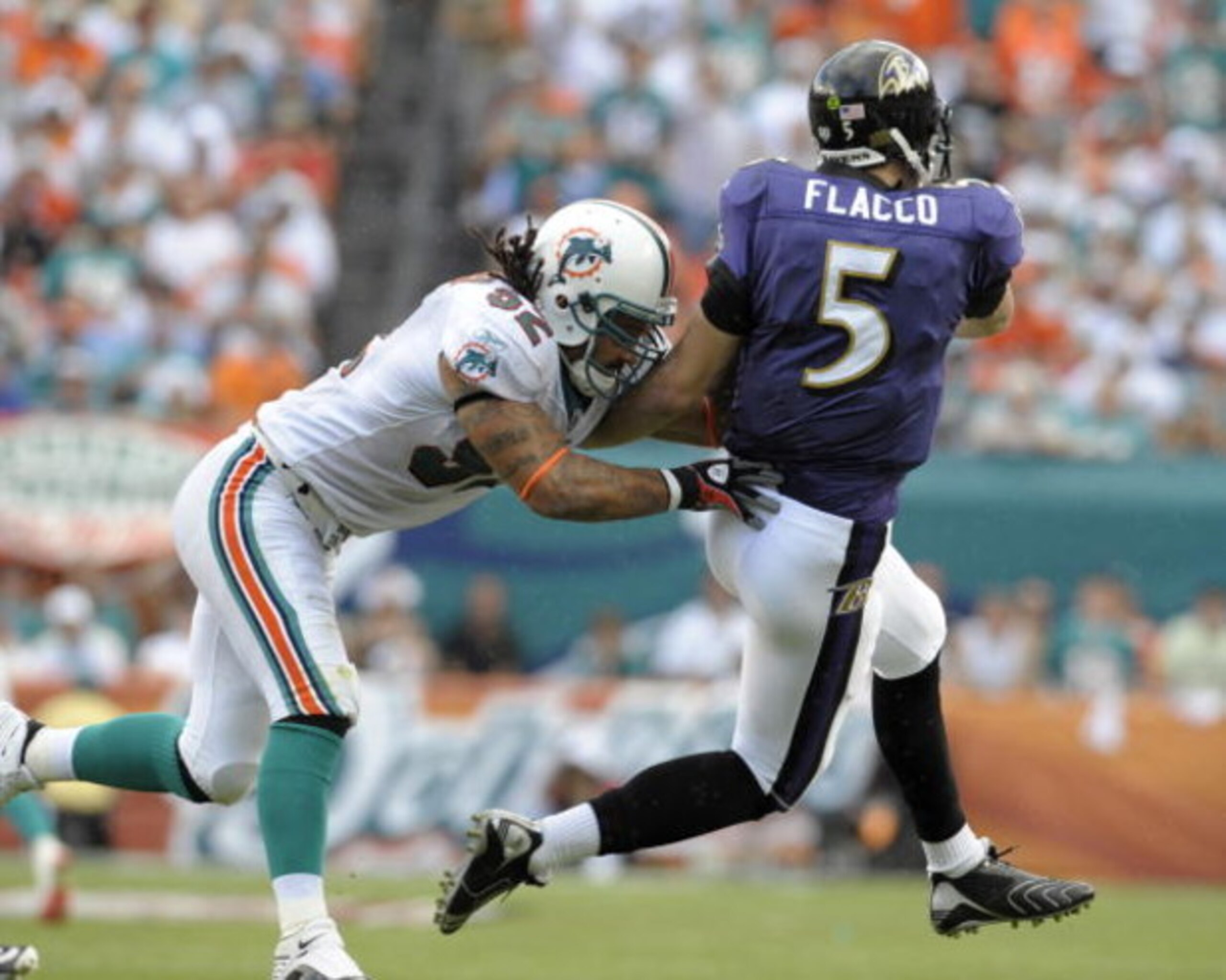 MIAMI, FL - JANUARY 4:  Linebacker Channing Crowder #52 of the Miami Dolphins hits quarterback Joe Flacco #5 of the Baltimore Ravens in an AFC wild card game at Dolphins Stadium January 4, 2009 in Miami, Floirda.  (Photo by Al Messerschmidt/Getty Images)