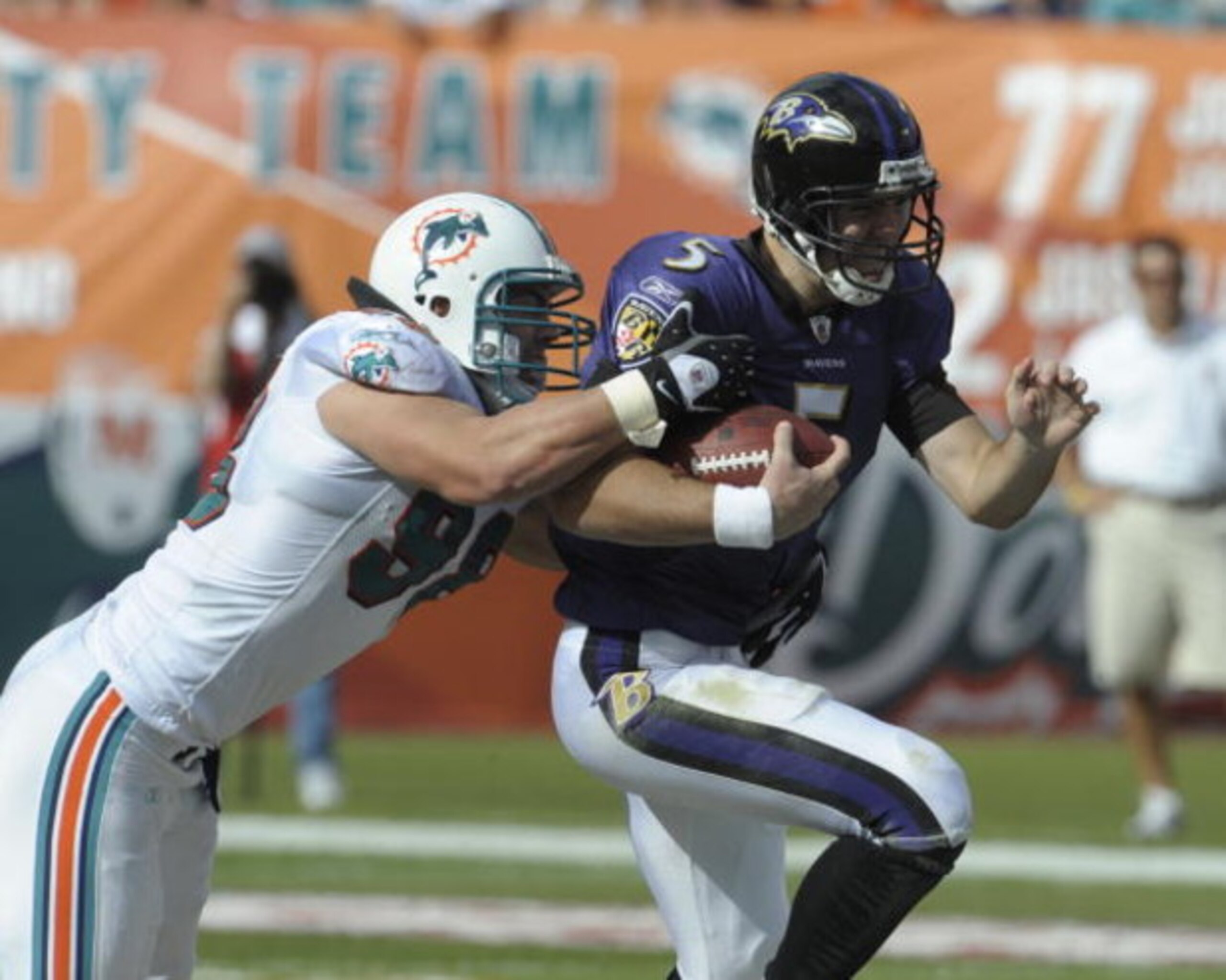 MIAMI, FL - JANUARY 4:  Linebacker Matt Roth #98 of the Miami Dolphins tackles quarterback Joe Flacco #5 of the Baltimore Ravens  in an NFL Wildcard Playoff Game at Dolphins Stadium on January 4, 2009 in Miami, Florida.  (Photo by Al Messerschmidt/Getty I