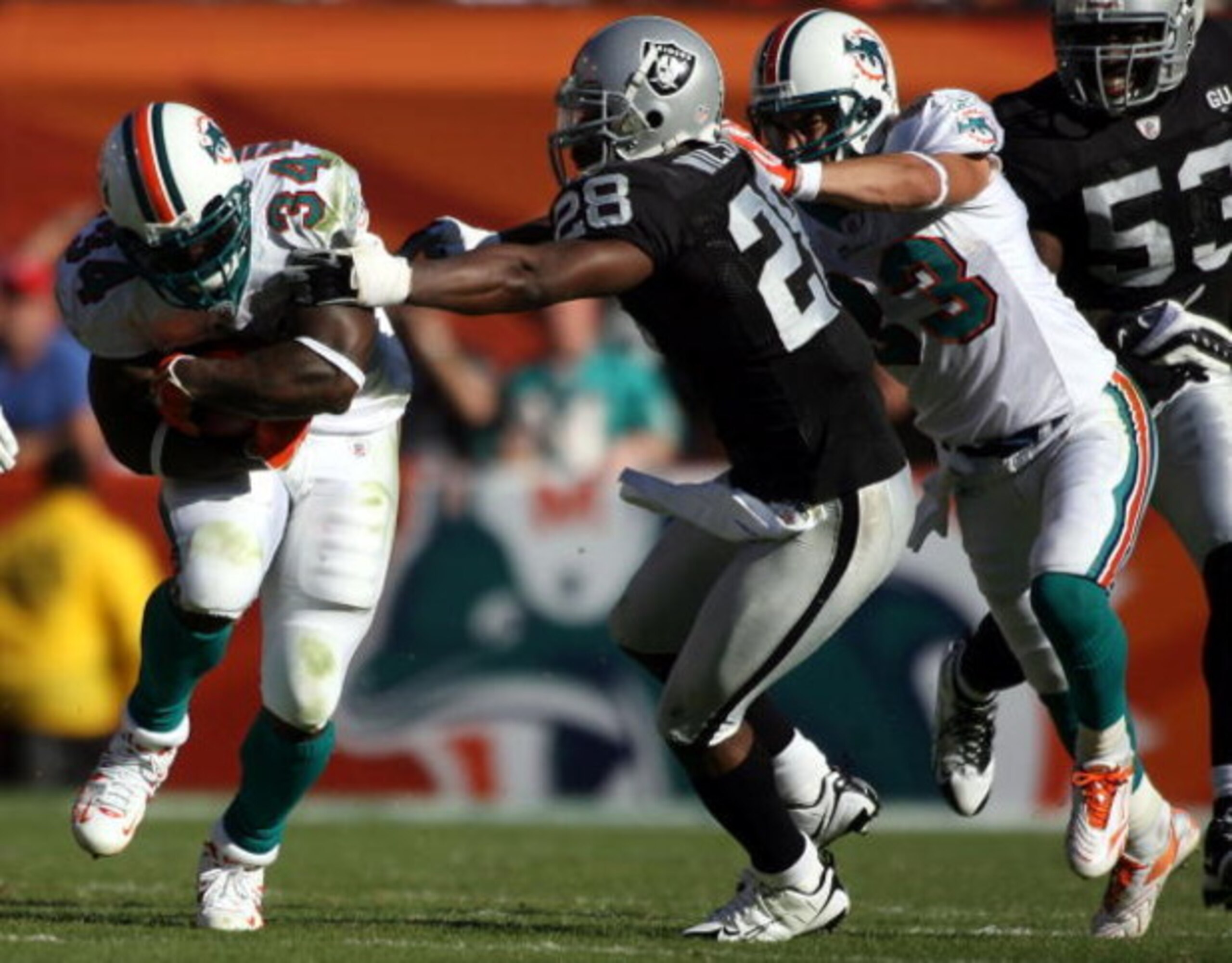 MIAMI - NOVEMBER 16:  Running back Ricky Williams #34 of the Miami Dolphins runs away from safety Gibril Wilson #28 of the Oakland Raiders in the second quarter at Dolphin Stadium November 16, 2008 in Miami, Florida. Miami defeated Oakland 17-15.  (Photo 