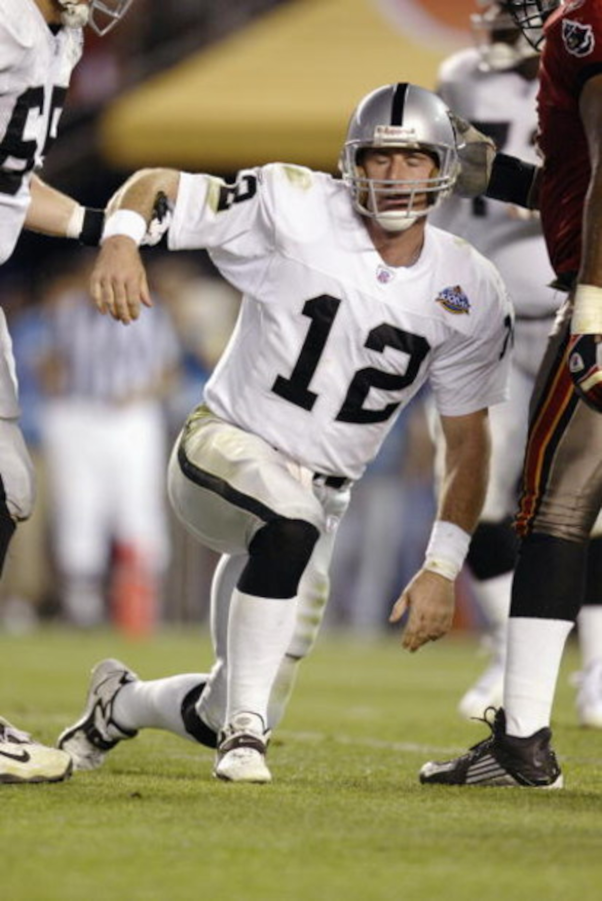 SAN DIEGO - JANUARY 26: Quarterback Rich Gannon #12 of the Oakland Raiders gets picked up after being sacked for a one yard loss by Ellis Wyms #96 of the Tampa Bay Buccaneers at the Oakland 17 yardline at 4:41 of the third quarter of Super Bowl XXXVII on SAN DIEGO - JANUARY 26: Quarterback Rich Gannon #12 of the Oakland Raiders gets picked up after being sacked for a one yard loss by Ellis Wyms #96 of the Tampa Bay Buccaneers at the Oakland 17 yardline at 4:41 of the third quarter of Super Bowl XXXVII on