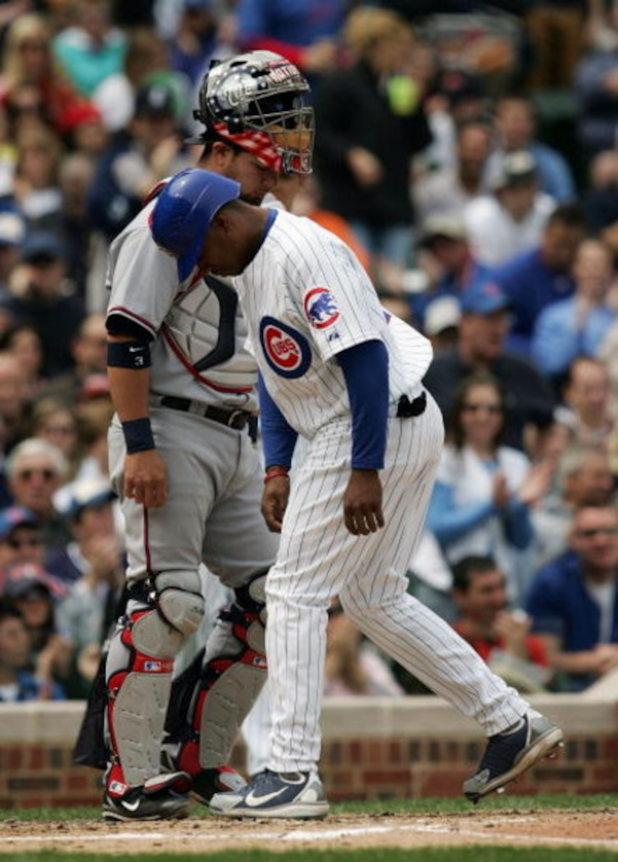 CHICAGO - MAY 05: Jacque Jones #11 of the Chicago Cubs scores the first of three Cub runs past catcher Jesus Flores #3 of the Washington Nationals that were walked in by pitcher Levale Speigner in the third inning on May 5, 2007 at Wrigley Field in Chicag