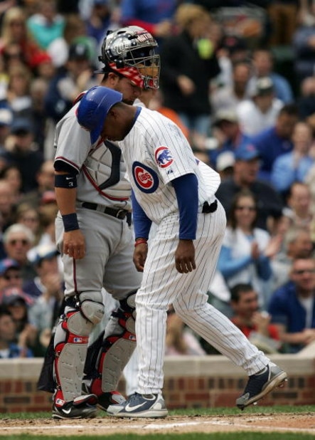 CHICAGO - MAY 05: Jacque Jones #11 of the Chicago Cubs scores the first of three Cub runs past catcher Jesus Flores #3 of the Washington Nationals that were walked in by pitcher Levale Speigner in the third inning on May 5, 2007 at Wrigley Field in Chicag