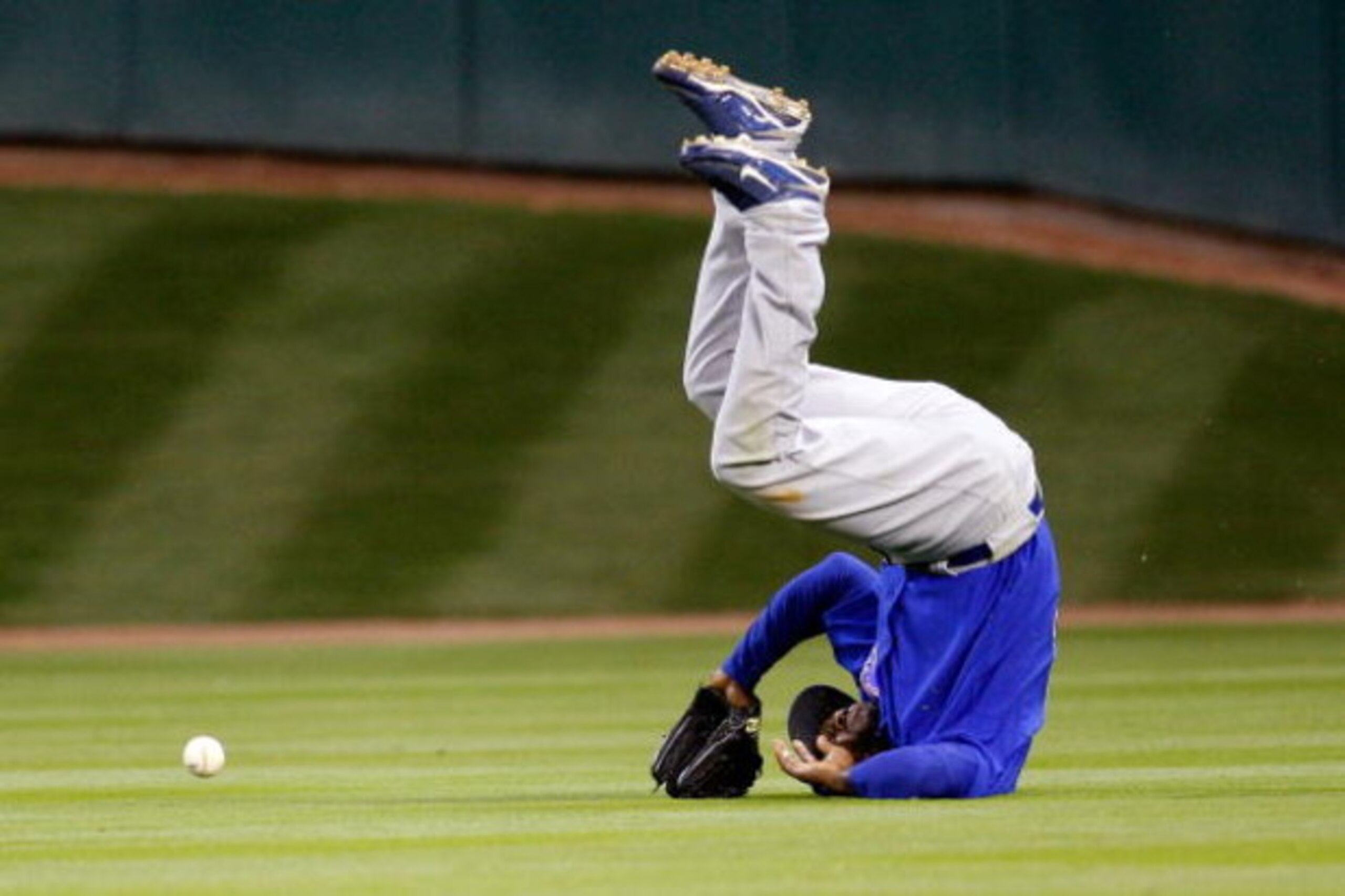 HOUSTON - APRIL 06:  Milton Bradley #21 of the Chicago Cubs flips over after missing a fly ball against the Houston Astros on Opening Day on April 6, 2009 at Minute Maid Park in Houston, Texas.  The Cubs defeated the Astros 4-2.  (Photo by Chris Graythen/