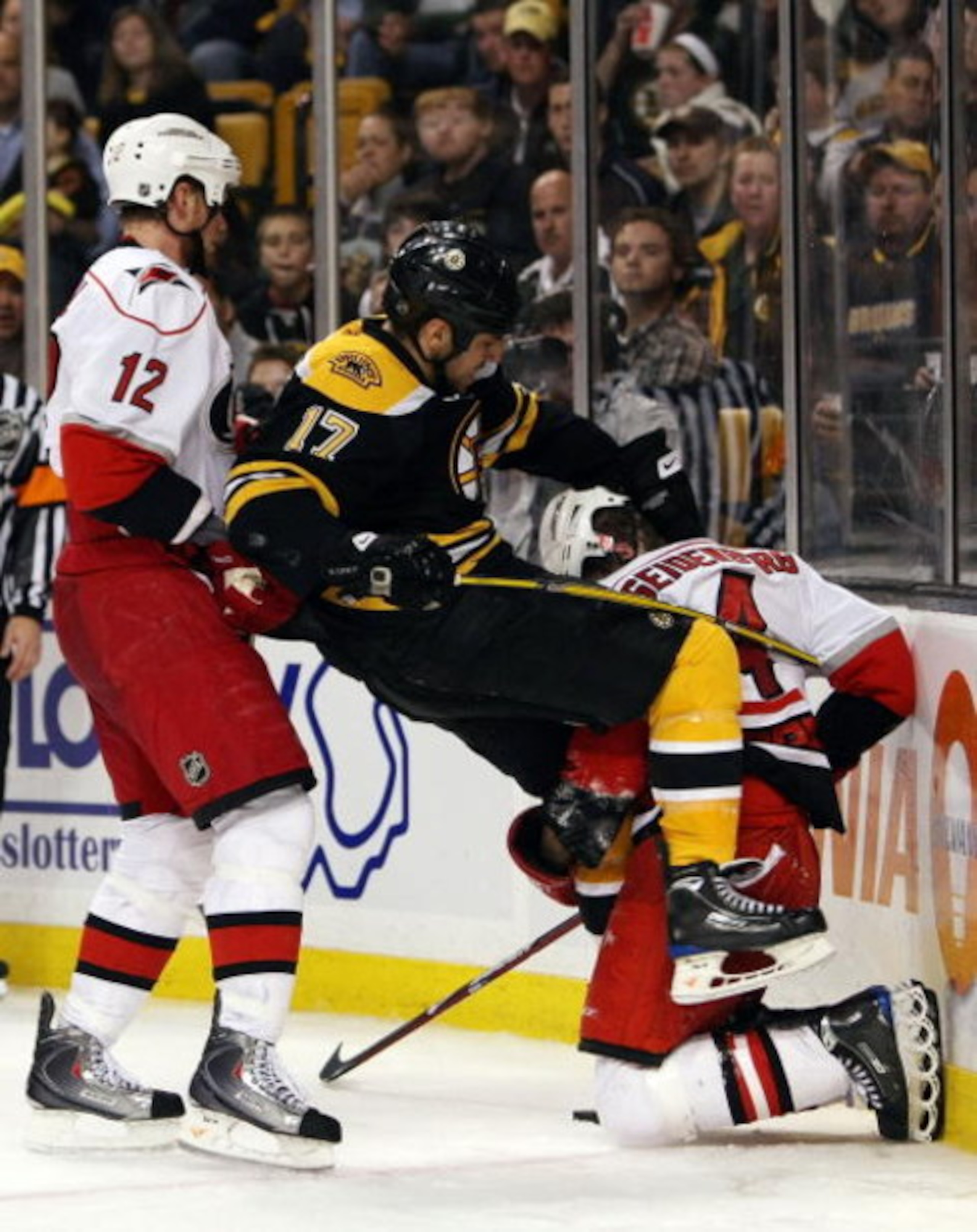 BOSTON - MAY 03:  Eric Staal #12 of the Carolina Hurricanes shoves Milan Lucic #17 of the Boston Bruins as Dennis Seidenberg #4 of the Hurricanes tips Lucic during Game Two of the Eastern Conference Semifinal Round of the 2009 Stanley Cup Playoffs on May 