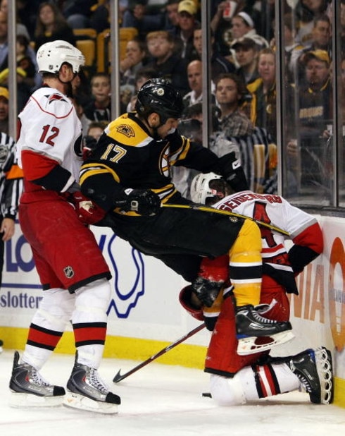 BOSTON - MAY 03:  Eric Staal #12 of the Carolina Hurricanes shoves Milan Lucic #17 of the Boston Bruins as Dennis Seidenberg #4 of the Hurricanes tips Lucic during Game Two of the Eastern Conference Semifinal Round of the 2009 Stanley Cup Playoffs on May 