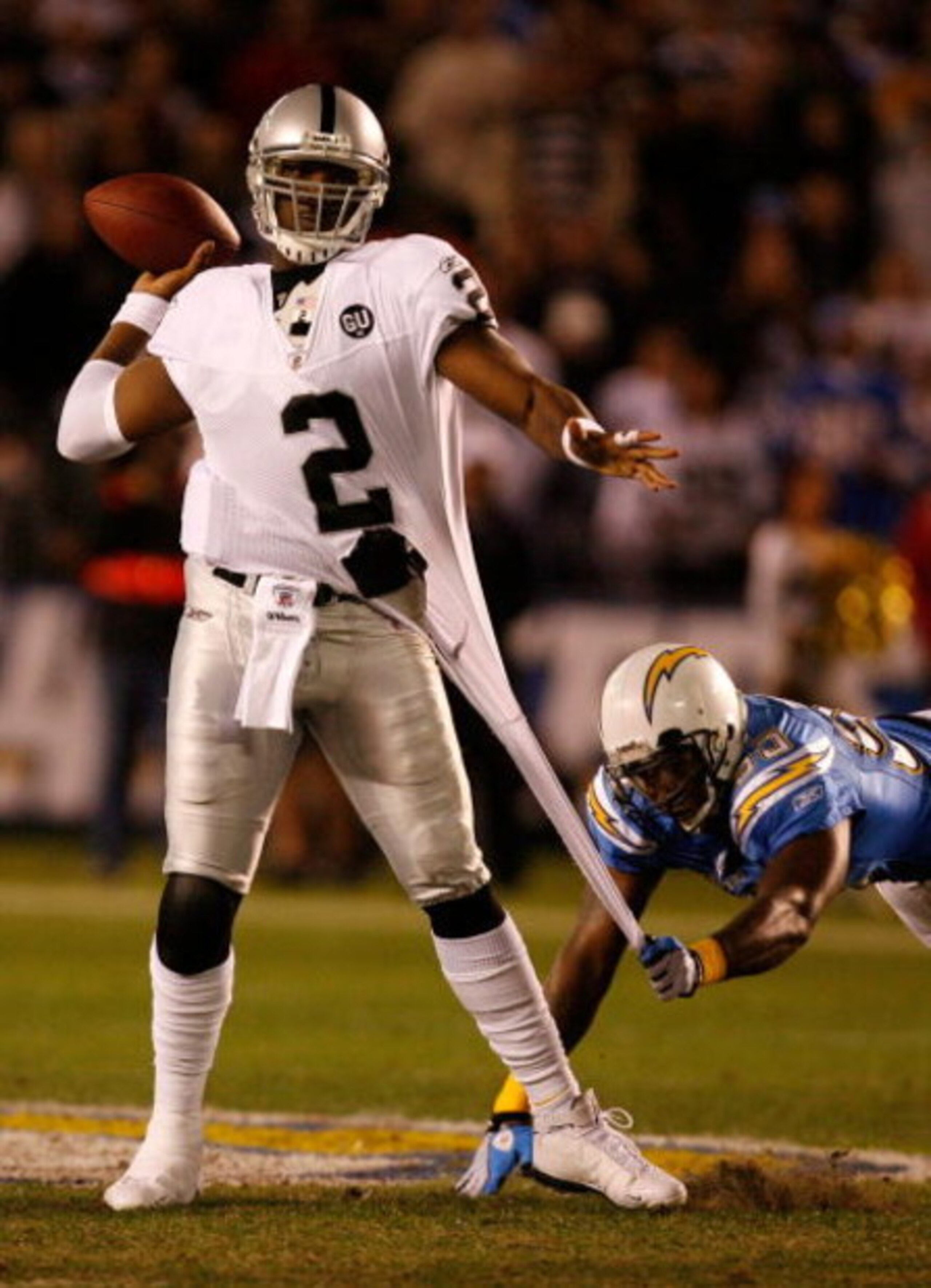 SAN DIEGO - DECEMBER 04:  Quarterback JaMarcus Russell #2 of the Oakland Raiders is grabbed by Linebacker Shaun Philips #95 of the San Diego Chargers during their NFL Game on December 4, 2008 at Qualcomm Stadium in San Diego, California.  (Photo by Harry 