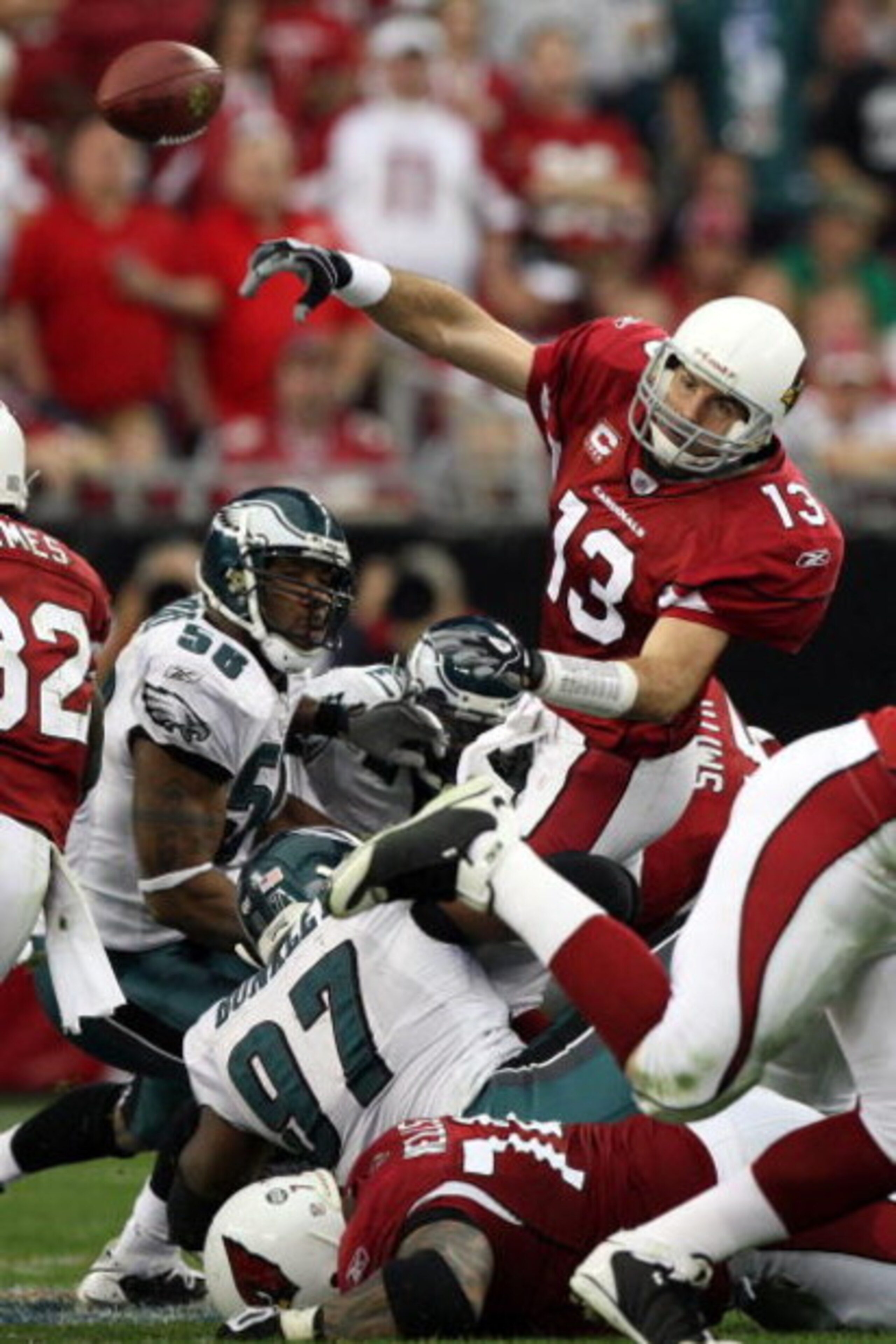 GLENDALE, AZ - JANUARY 18:  Quarterback Kurt Warner #13 of the Arizona Cardinals throws the ball as he is hit by Philadelphia Eagles defenders during the NFC championship game on January 18, 2009 at University of Phoenix Stadium in Glendale, Arizona.  (Ph