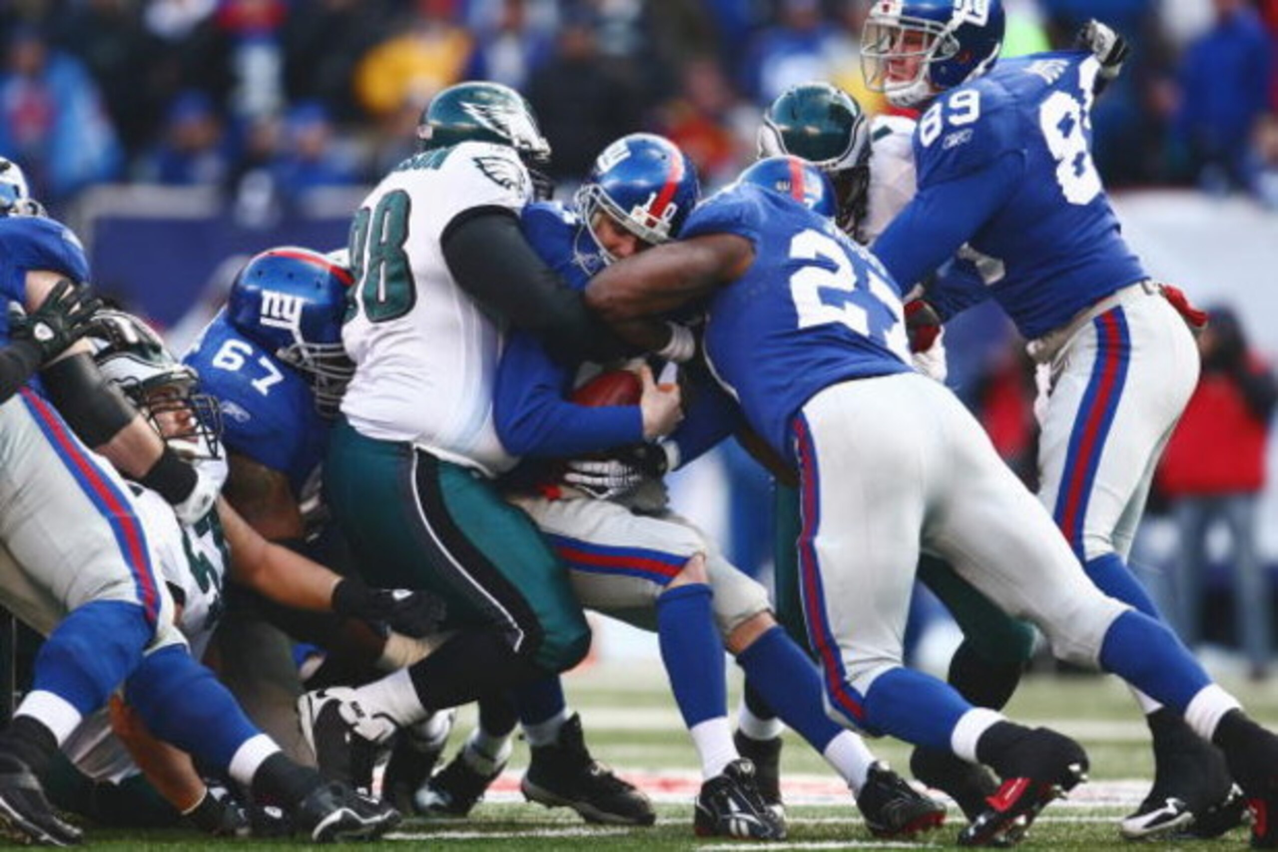 EAST RUTHERFORD, NJ -  JANUARY 11:  Eli Manning #10 of the New York Giants is tackled by Mike Patterson #98 of the Philadelphia Eagles during the NFC Divisional Playoff Game on January 11, 2009 at Giants Stadium in East Rutherford, New Jersey.  The Eagles