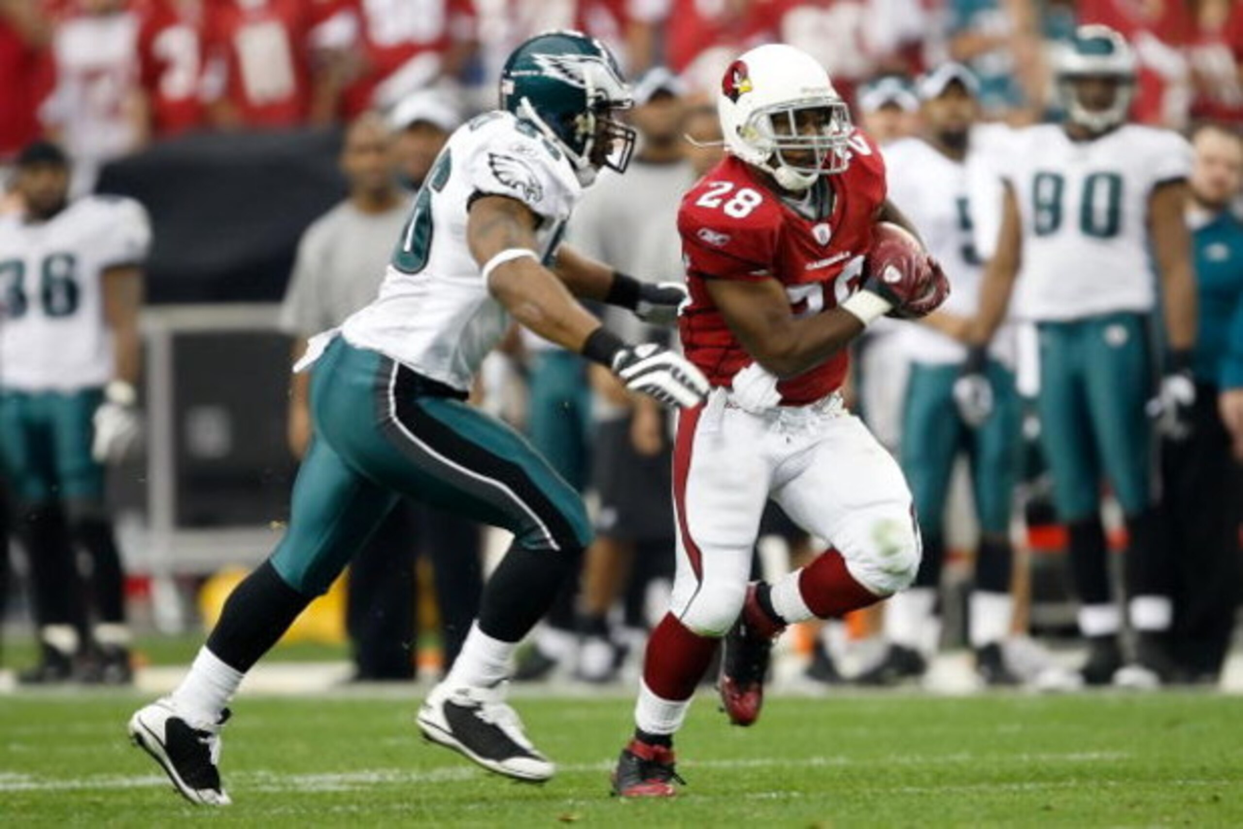 GLENDALE, AZ - JANUARY 18:  Running back J.J. Arrington #28 of the Arizona Cardinals runs the ball by linebacker Akeem Jordan #56 of the Philadelphia Eagles in the second quarter during the NFC championship game on January 18, 2009 at University of Phoeni