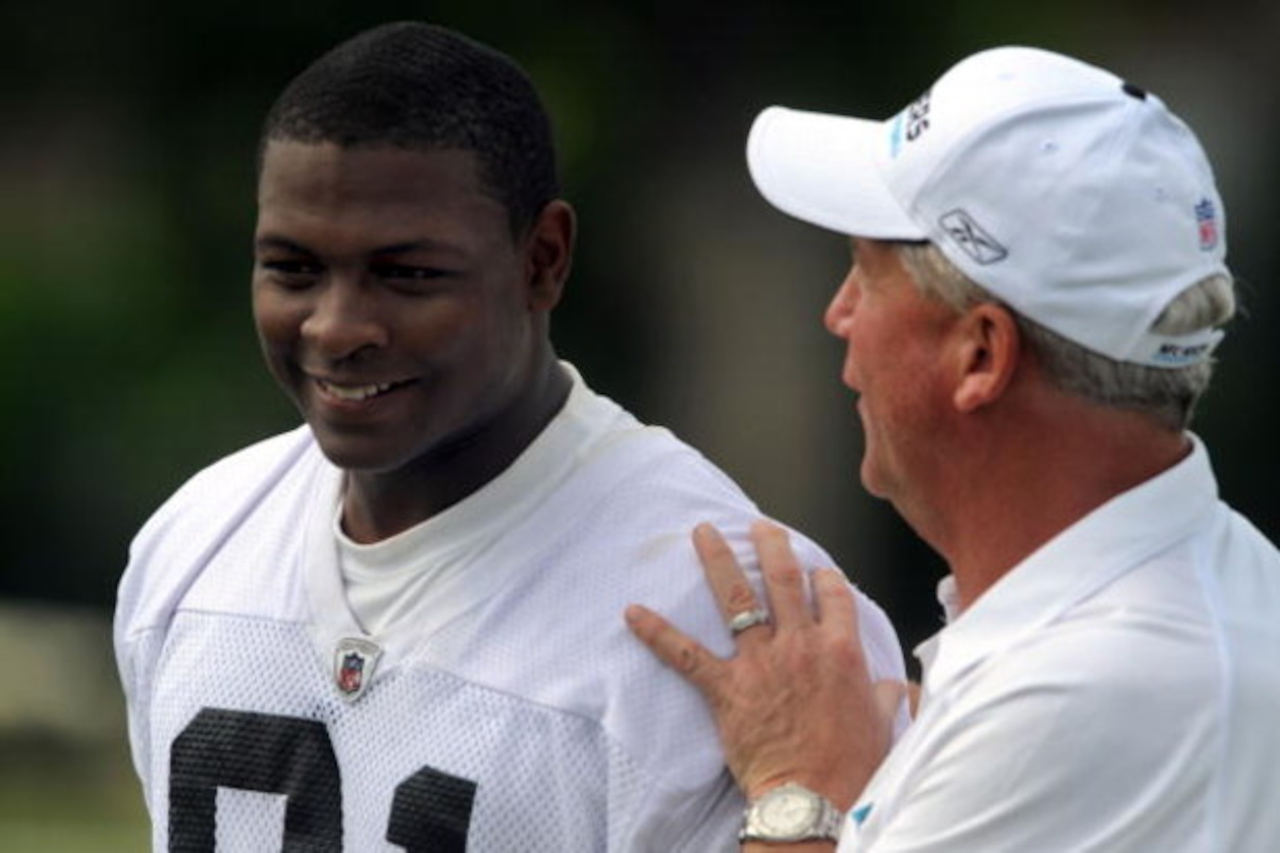CHARLOTTE,NC- MAY 1: First round draft pick Everette Brown #91 of the Carolina Panthers smiles as Head Coach John Fox (R) pats him on the back as they walk off the field the minicamp practice at the team's practice facility on May 1, 2009 in Charlotte, No