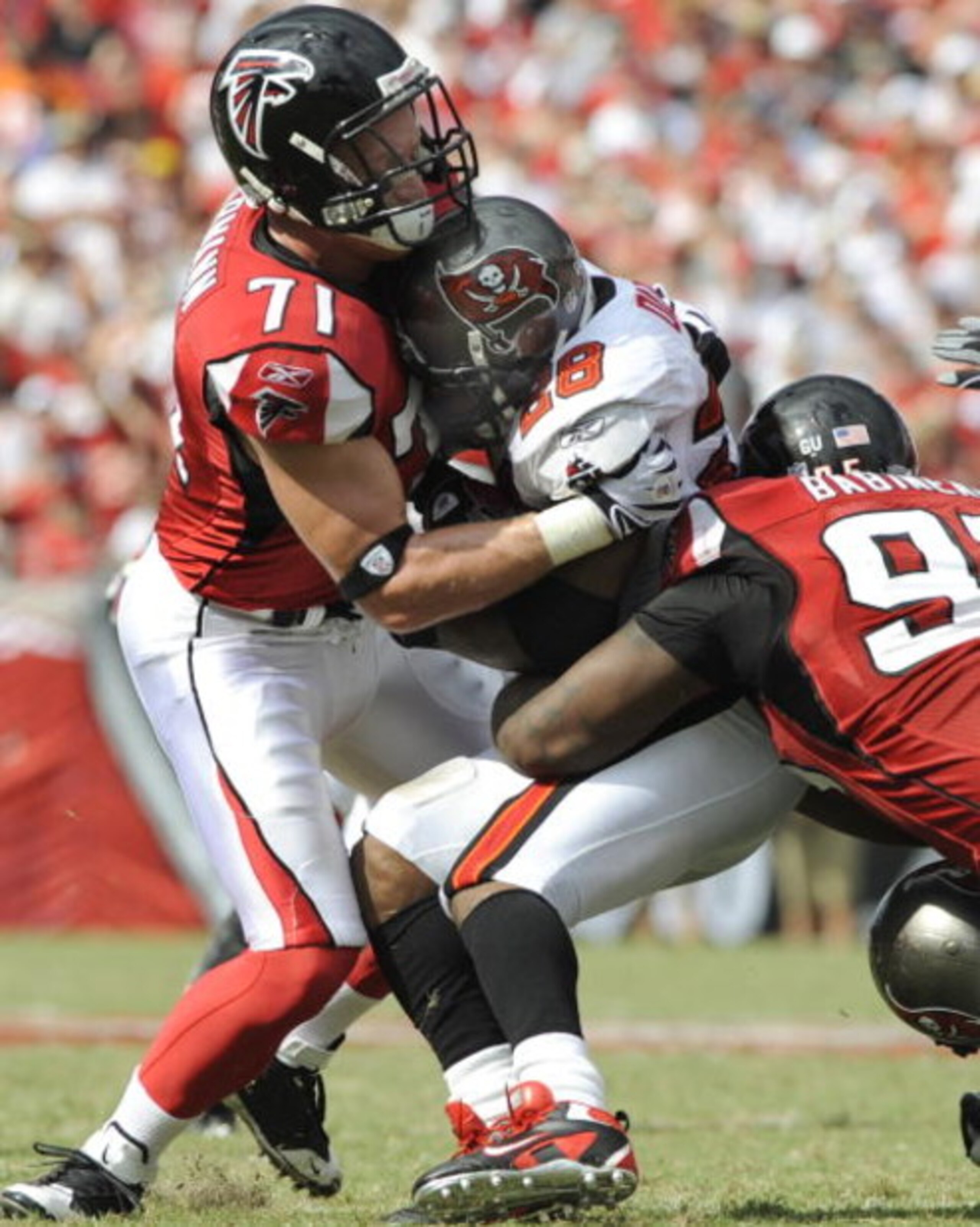 TAMPA, FL - SEPTEMBER 14: Defensive tackle Jonathan Babineaux #95 and defensive end Kroy Biermann #71 of the Atlanta Falcons stop running back Warrick Dunn #28 of the Tampa Bay Buccaneers at Raymond James Stadium on September 14, 2008 in Tampa, Florida.  